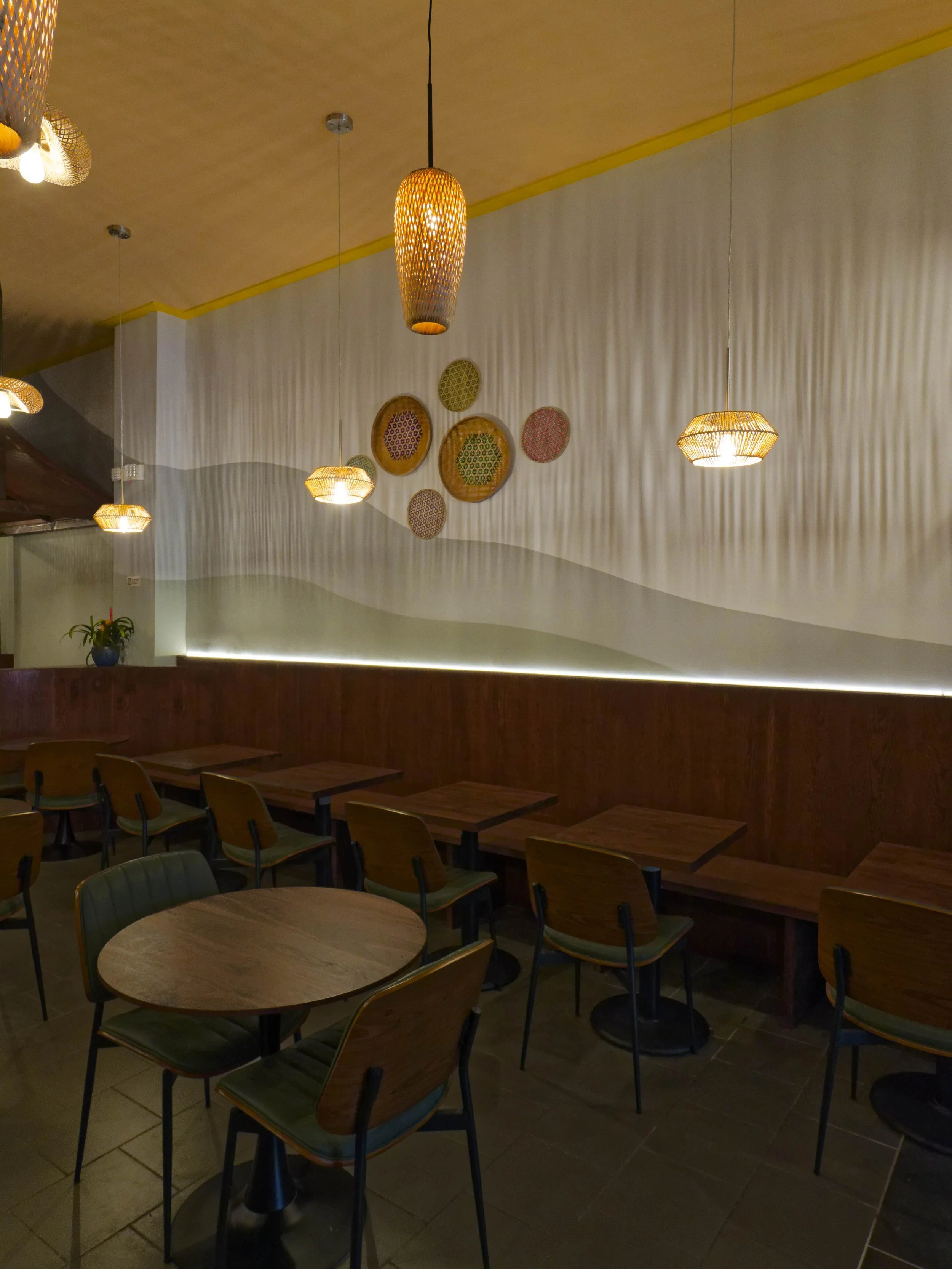 Custom banquette seating against textured white walls. Space-saving dining layout designed to maximize capacity in a Brooklyn Heights restaurant. Interior architecture by XZ Design Build NYC.