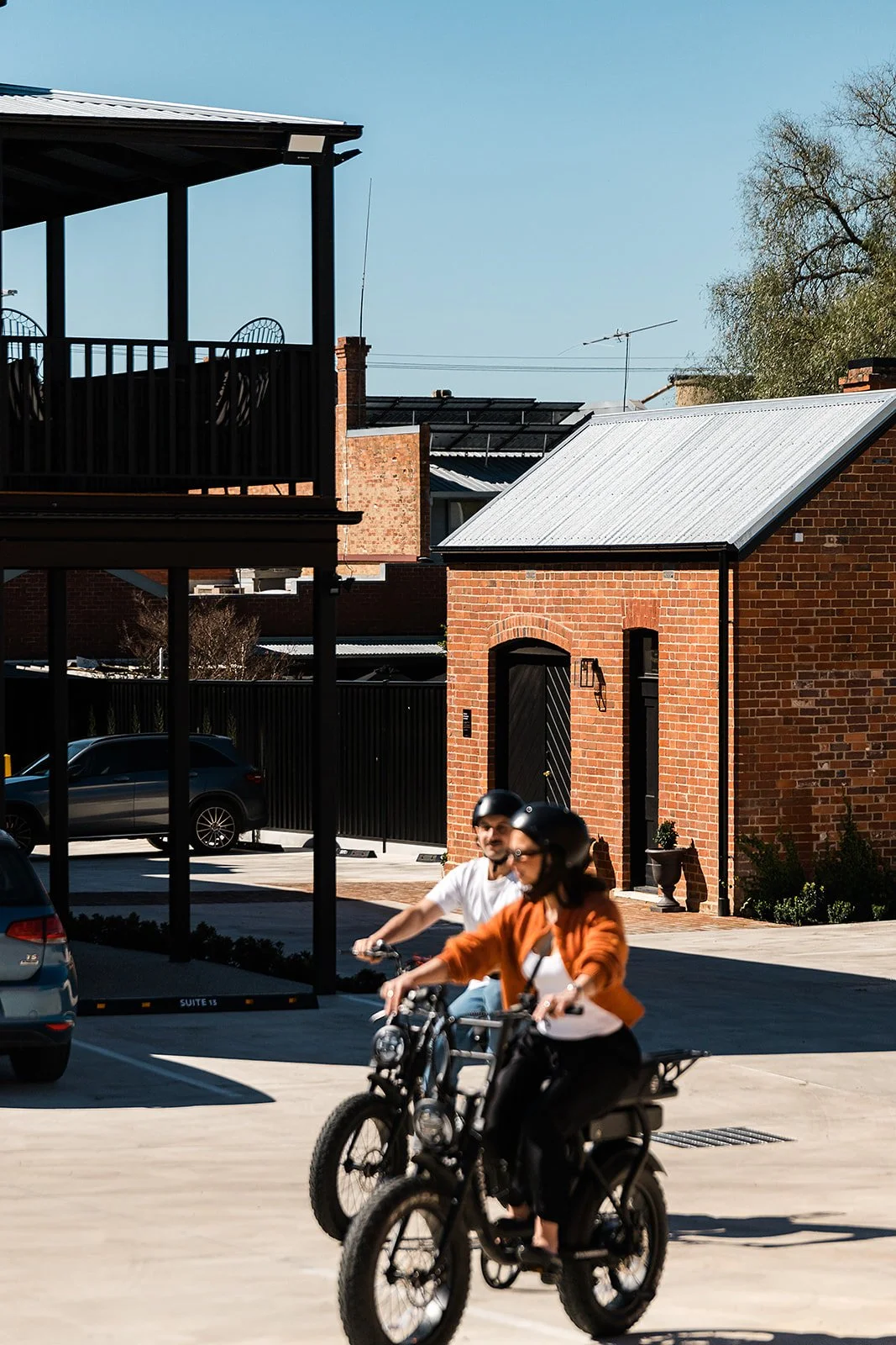 Hotel guests riding e-bikes past the boutique suites at The Victoria Rutherglen
