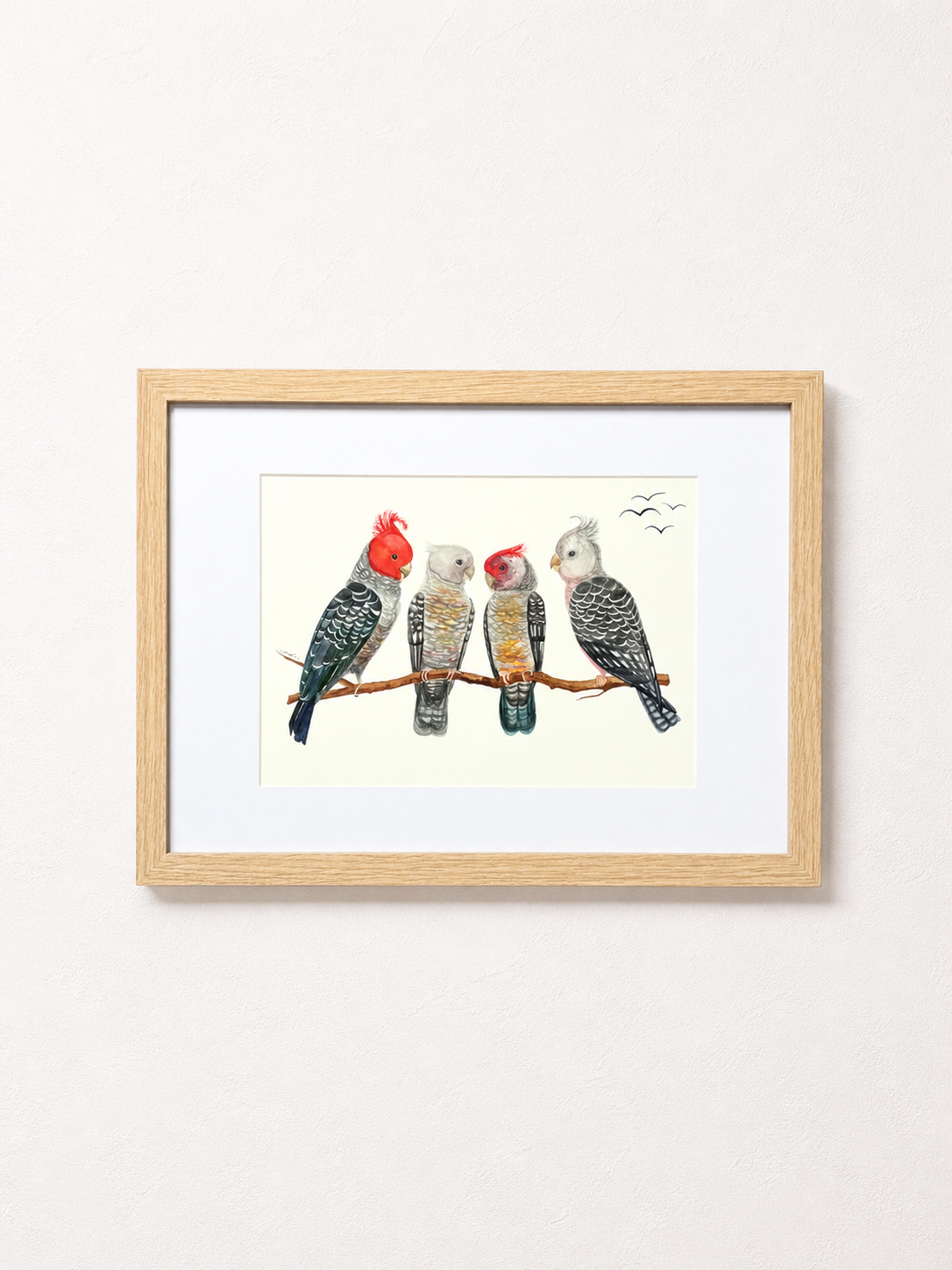 Framed watercolor painting of four colorful parrots sitting on a branch, with birds flying in the background.