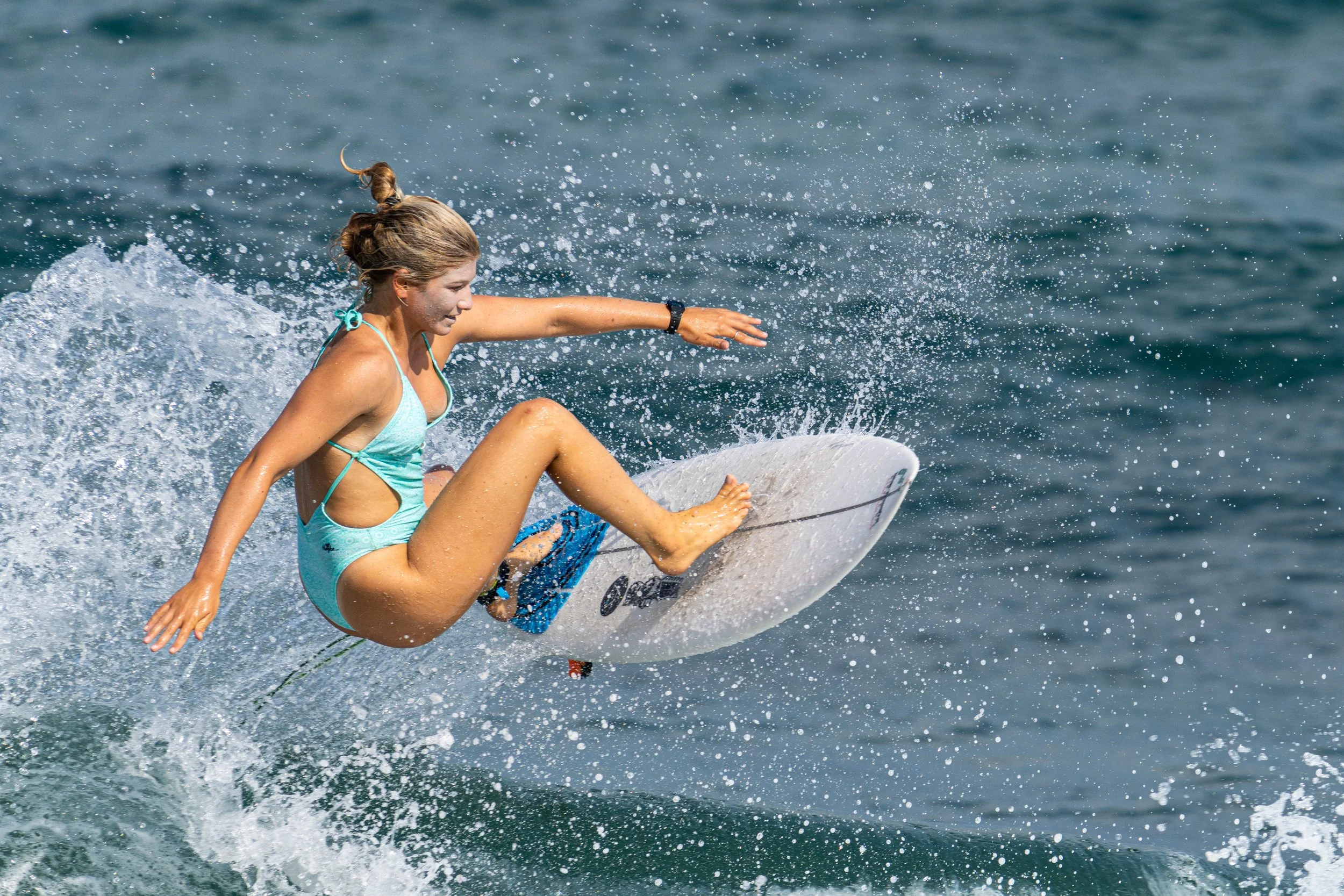 Olympic female surfer catching air and waves.