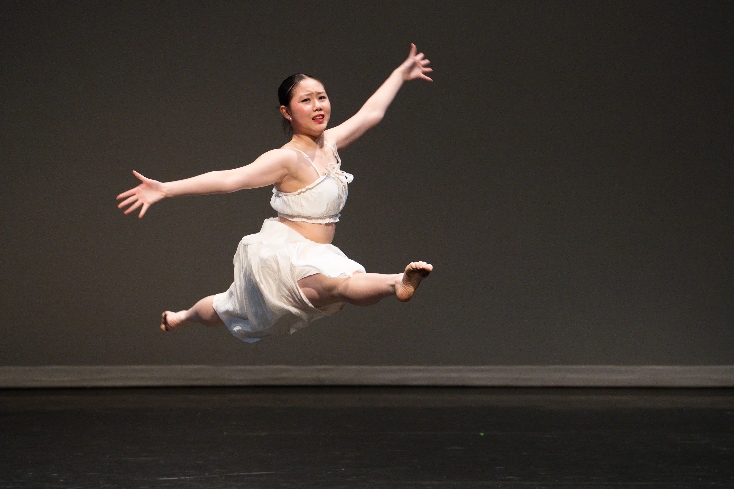 High-speed action photography of a dancer at the apex of a jump, showing weightlessness and power.