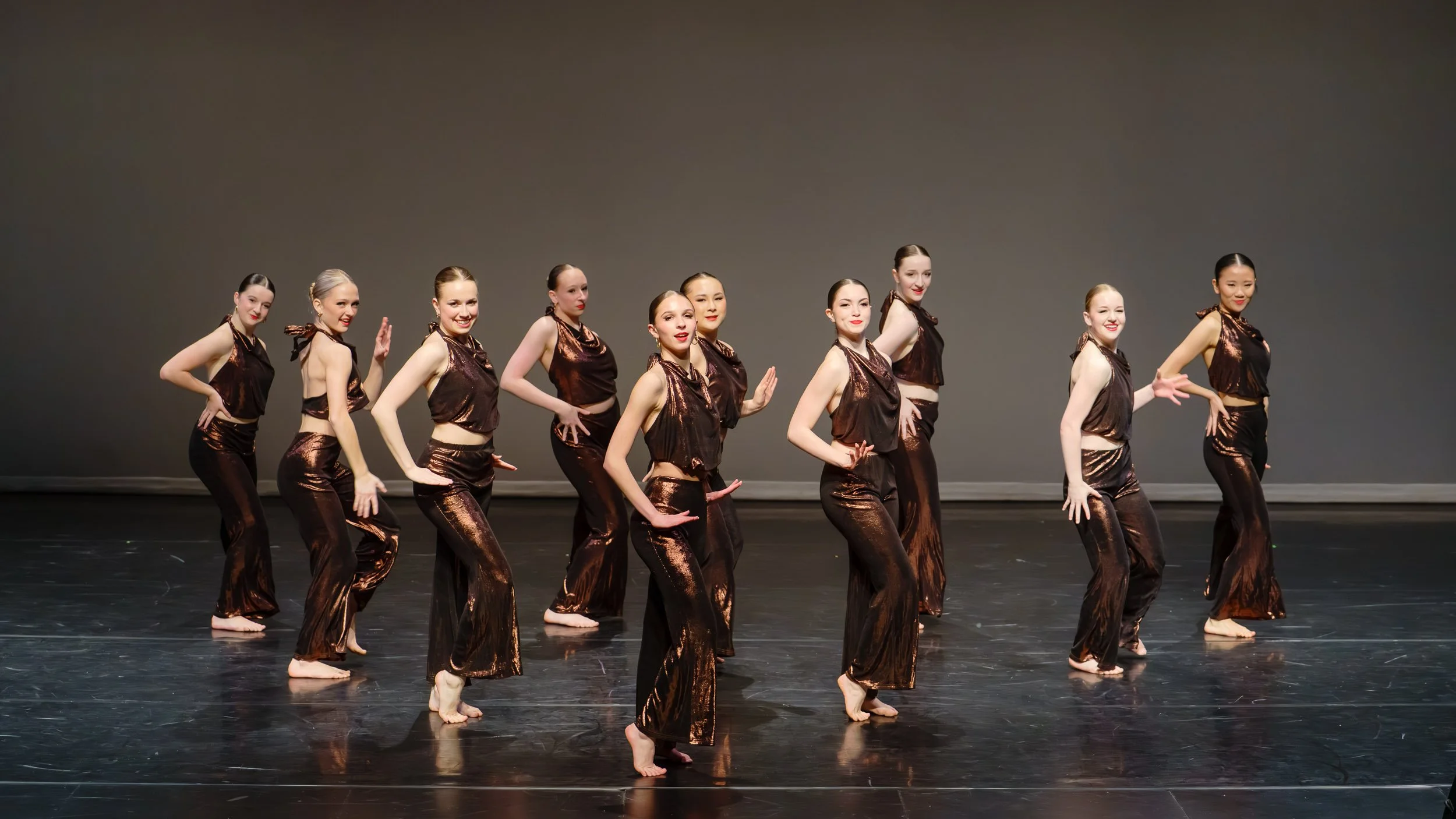 A group of dancers from Tri-City Dance Center performing with high energy and joyful expressions, captured by Peak Action Photography.
