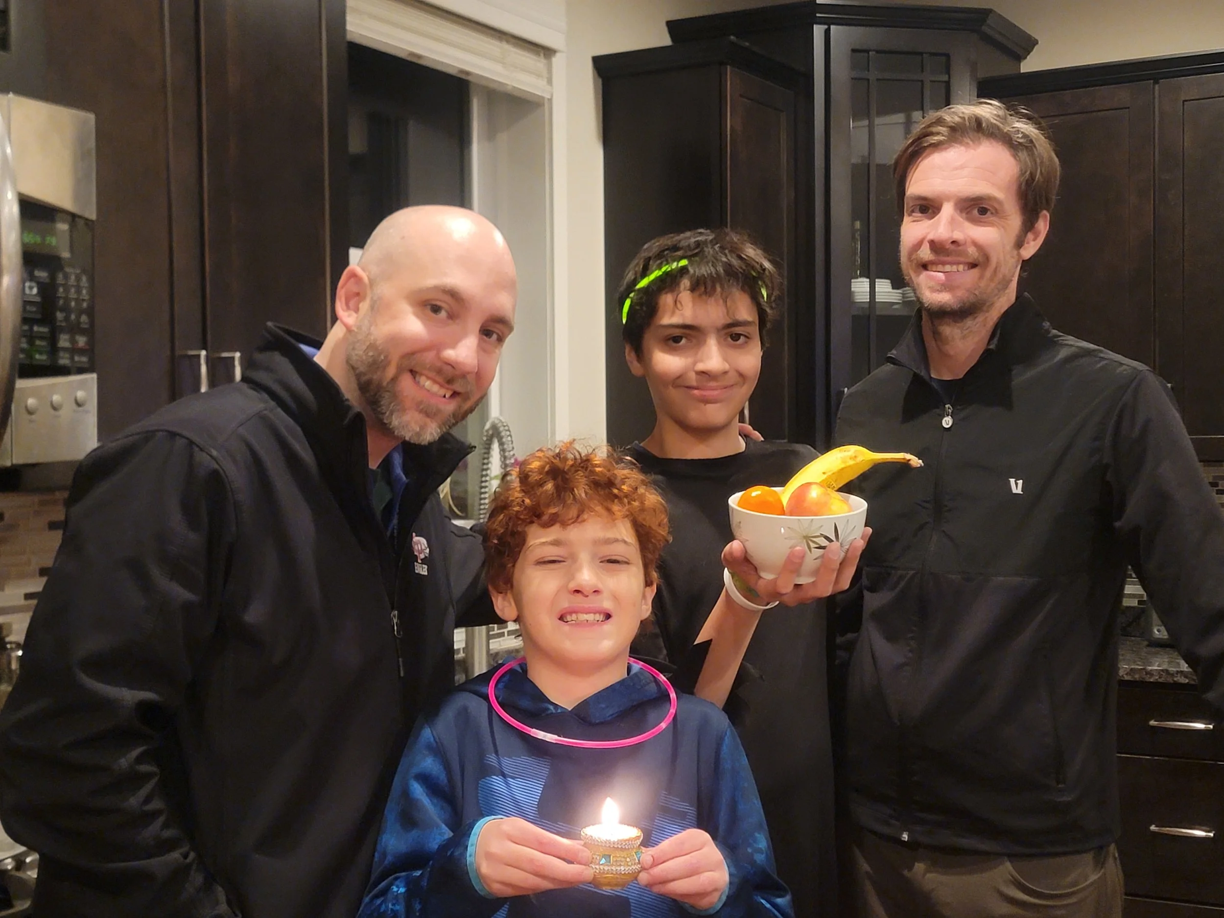 Dirk and his family celebrating Diwali with a lit diya and bowl of fruit