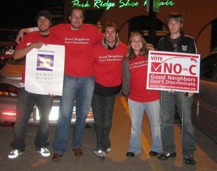 Dirk and other campaigners in red shirts that say "Good Neighbors Don't Discriminate" with some holding signs