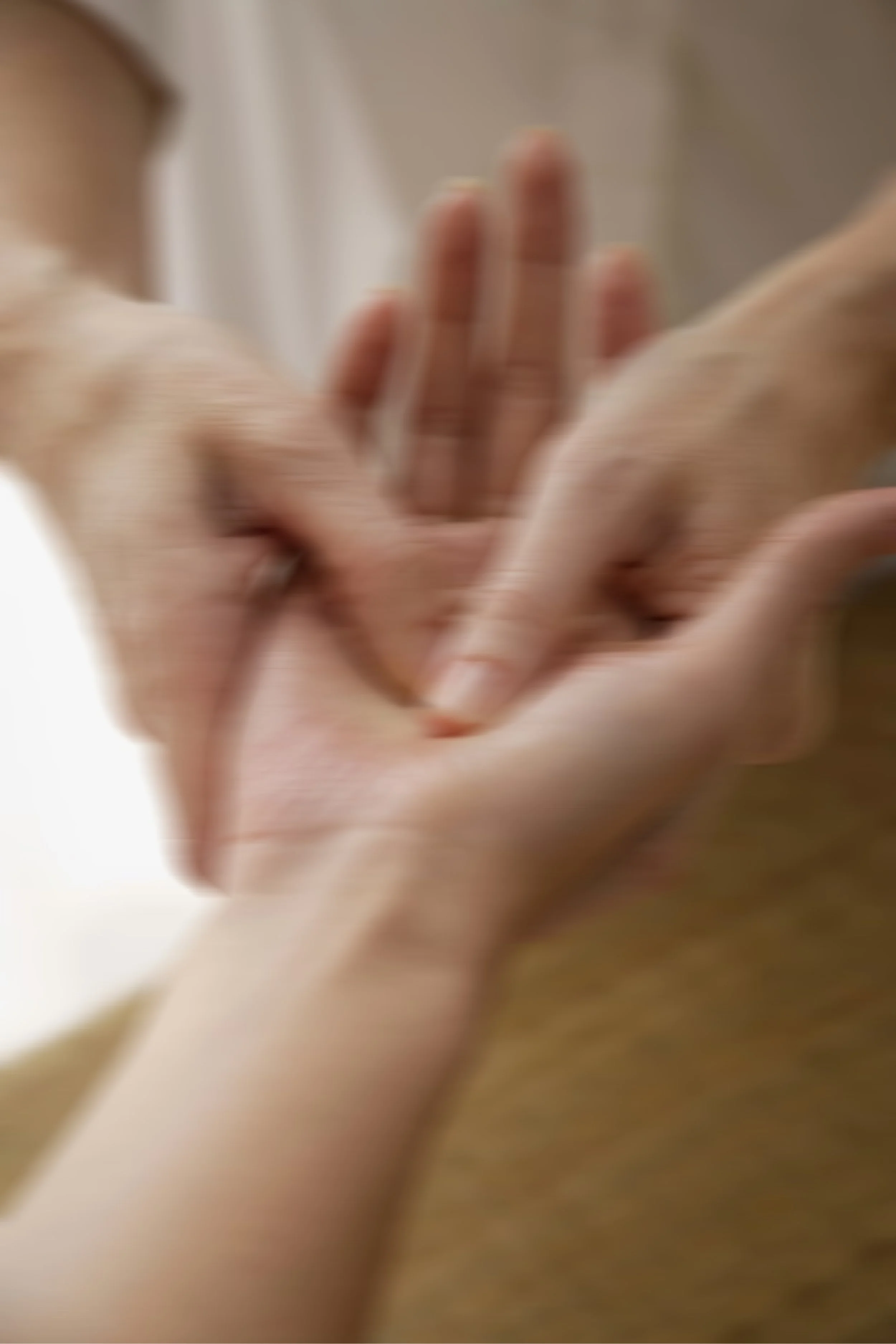 Close-up of two people's hands with the therapist massaging the clients palm.