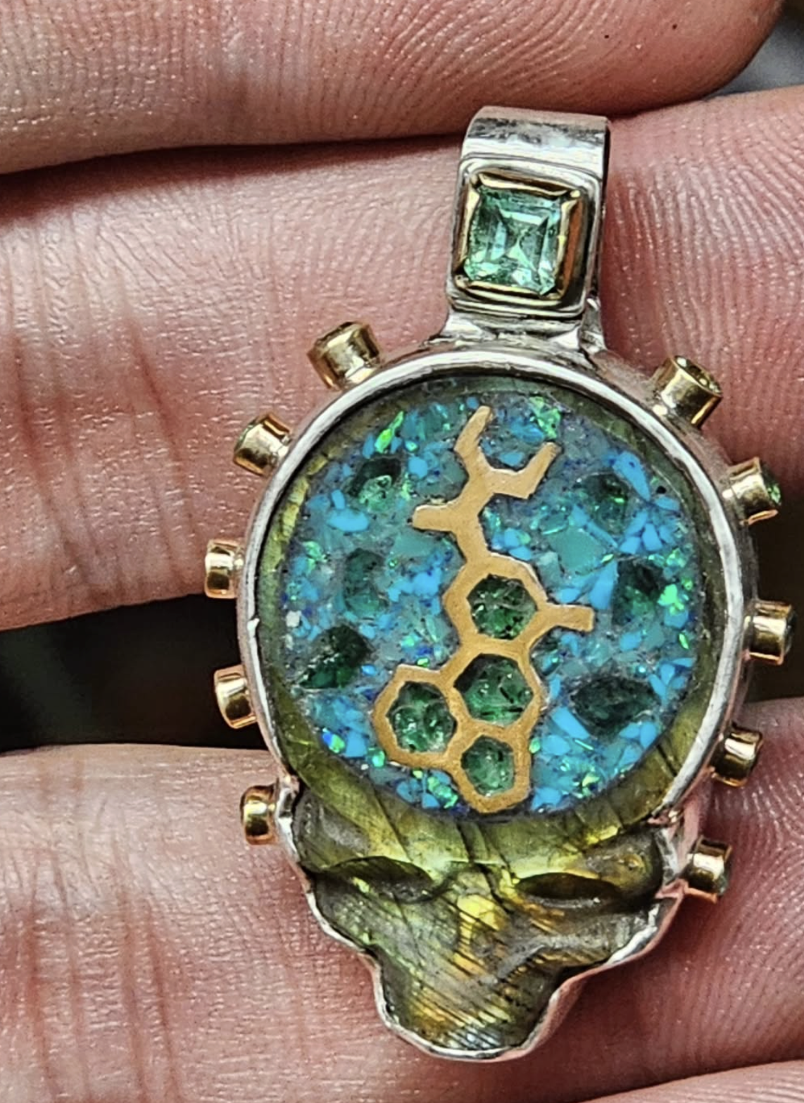 A wristwatch with a multicolored, glittery dial, gold accents, and a gemstone on the band.