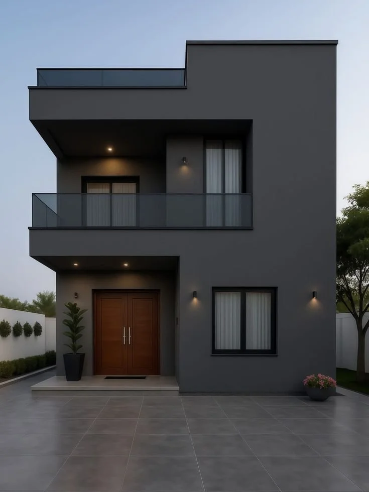 Fachada de una casa moderna de dos pisos con paredes grises y ventanas con cortinas blancas, entrada principal con puertas de madera y plantas decorativas a los lados.