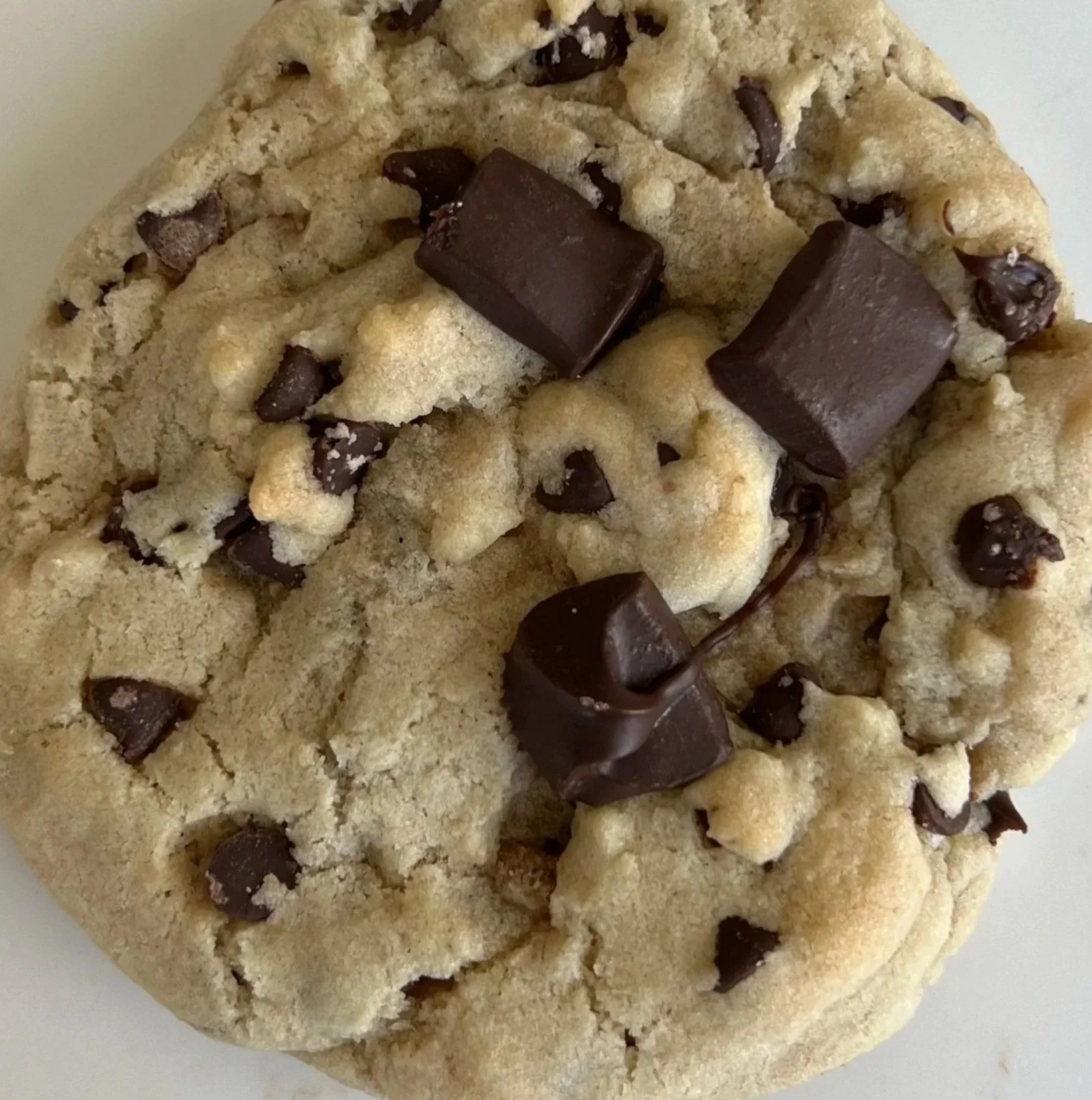 Close-up of a chocolate chip cookie with chunks of chocolate on top.