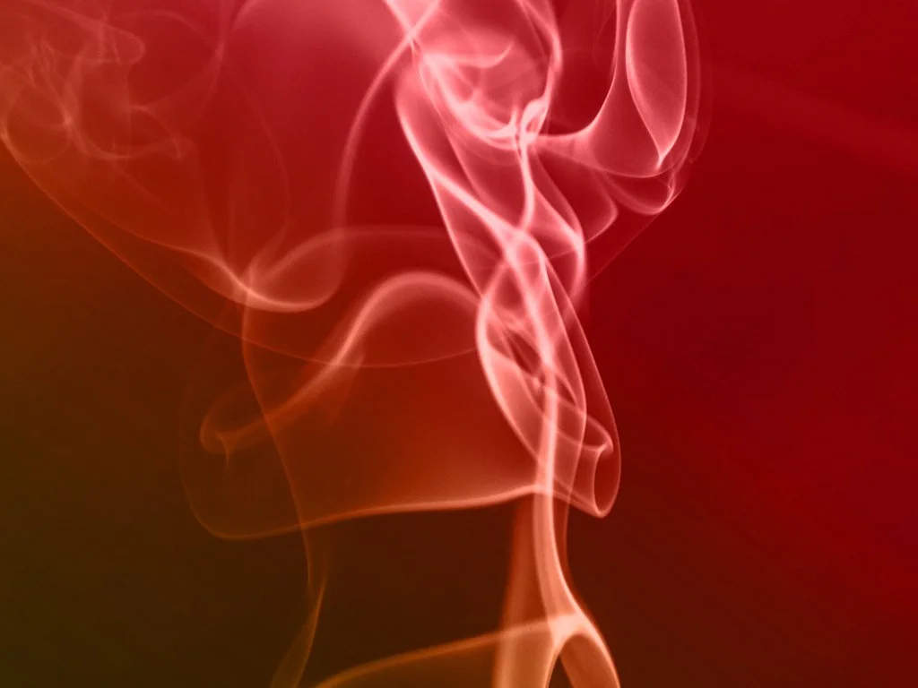 Pink and red swirling smoke or vapor against a dark background.