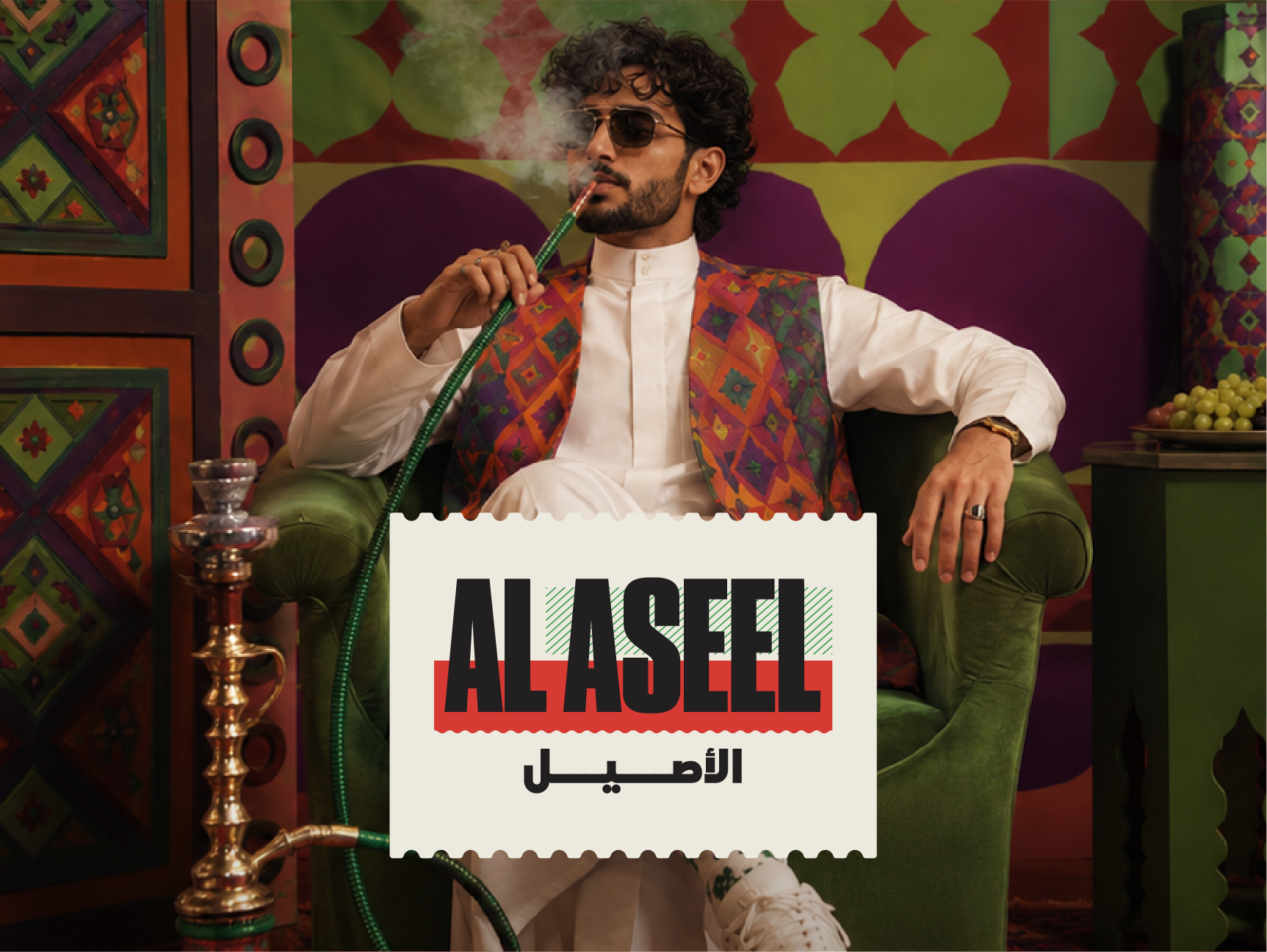 Man in traditional white attire and a colorful patterned vest seated in a green armchair, smoking shisha in a vibrant Middle Eastern-inspired interior, with an “AL ASEEL” logo graphic in the foreground.