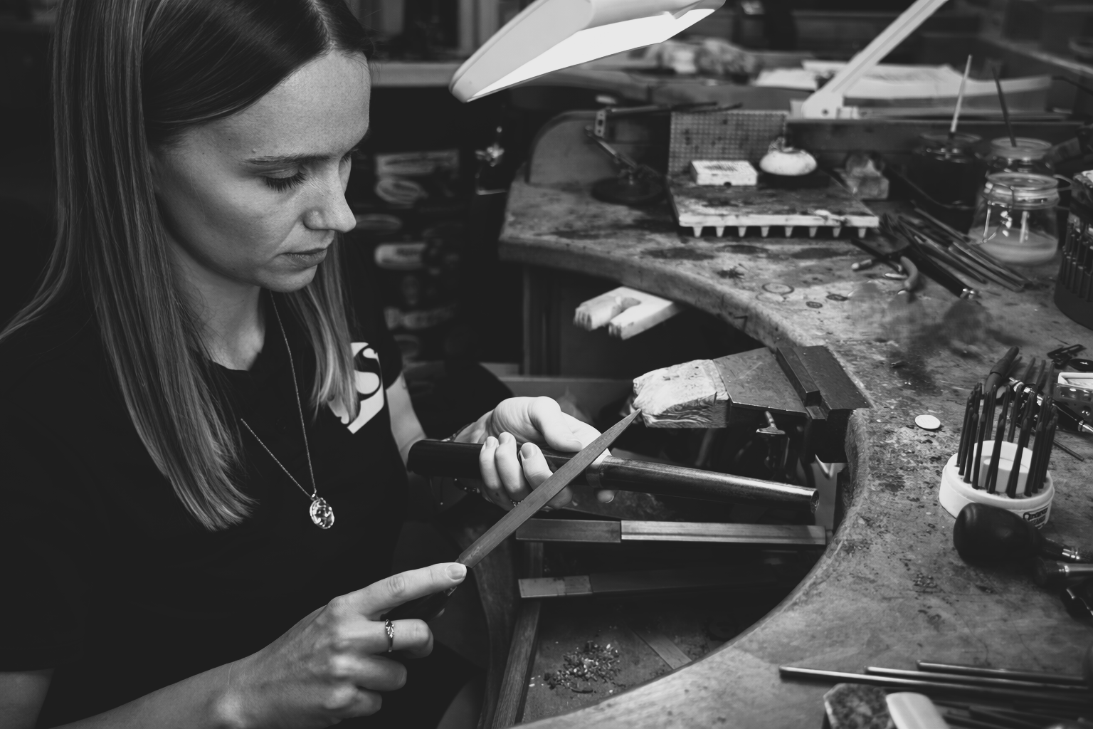 A jeweller using tools to make a custom ring in the workshop.