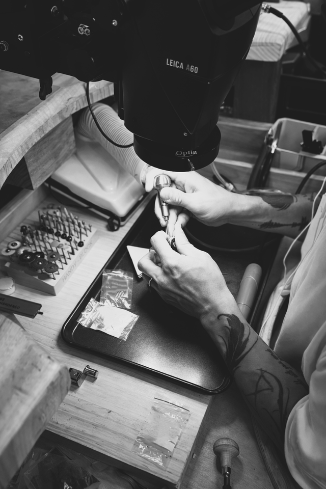 A jeweller stone setting a ring using specialised tools.