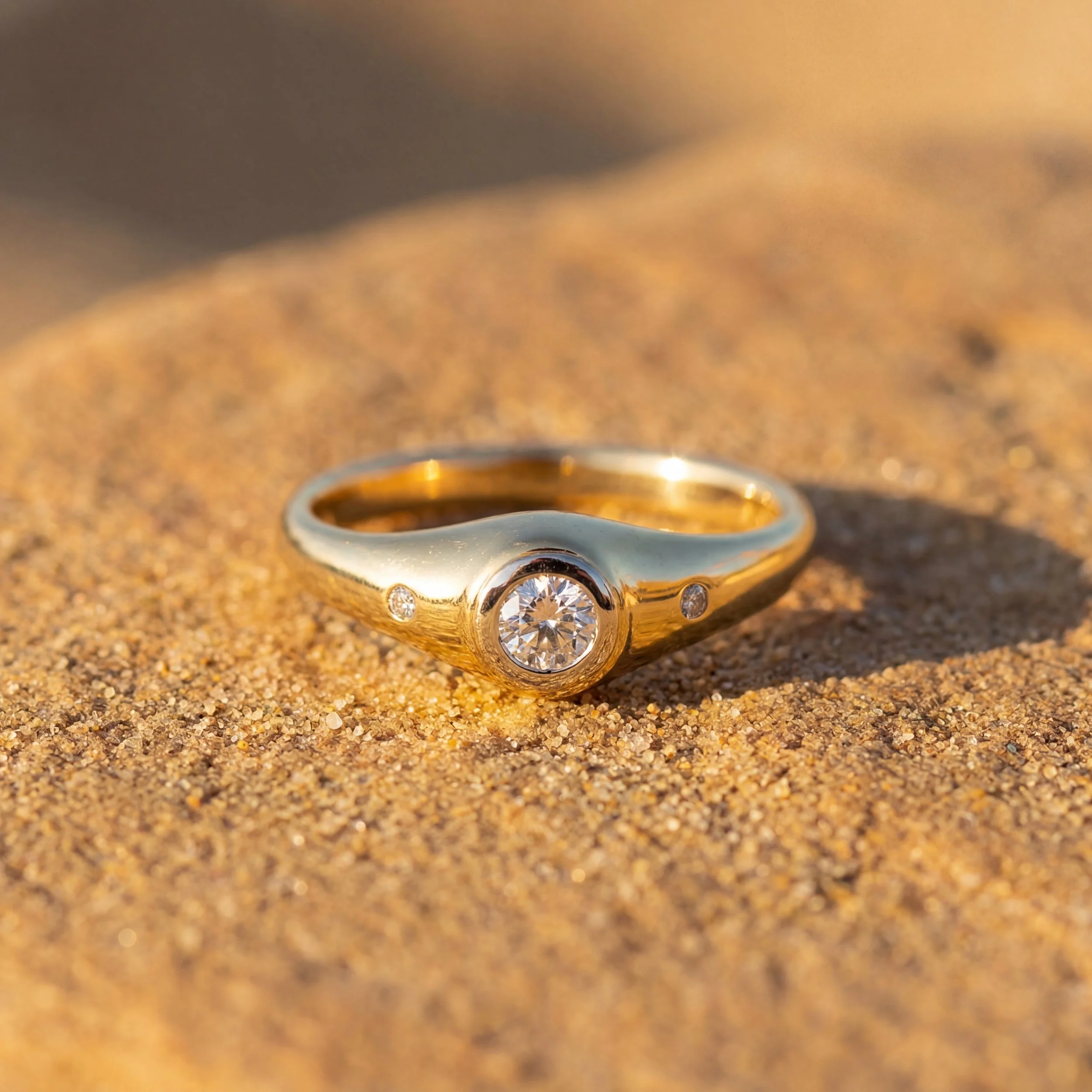 A gold ring with three circular diamonds.