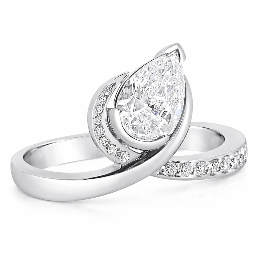 Anniversary ring set with a pear cut diamond and round brilliant cut diamonds in white gold.