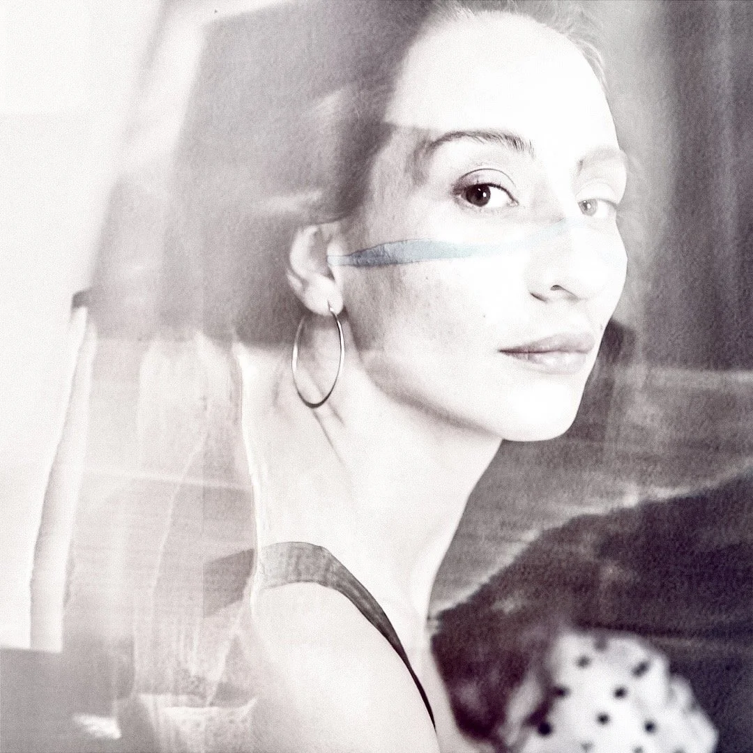 Retrato de perfil de una mujer con arete y camiseta de tirantes, en blanco y negro con efecto de doble exposición.