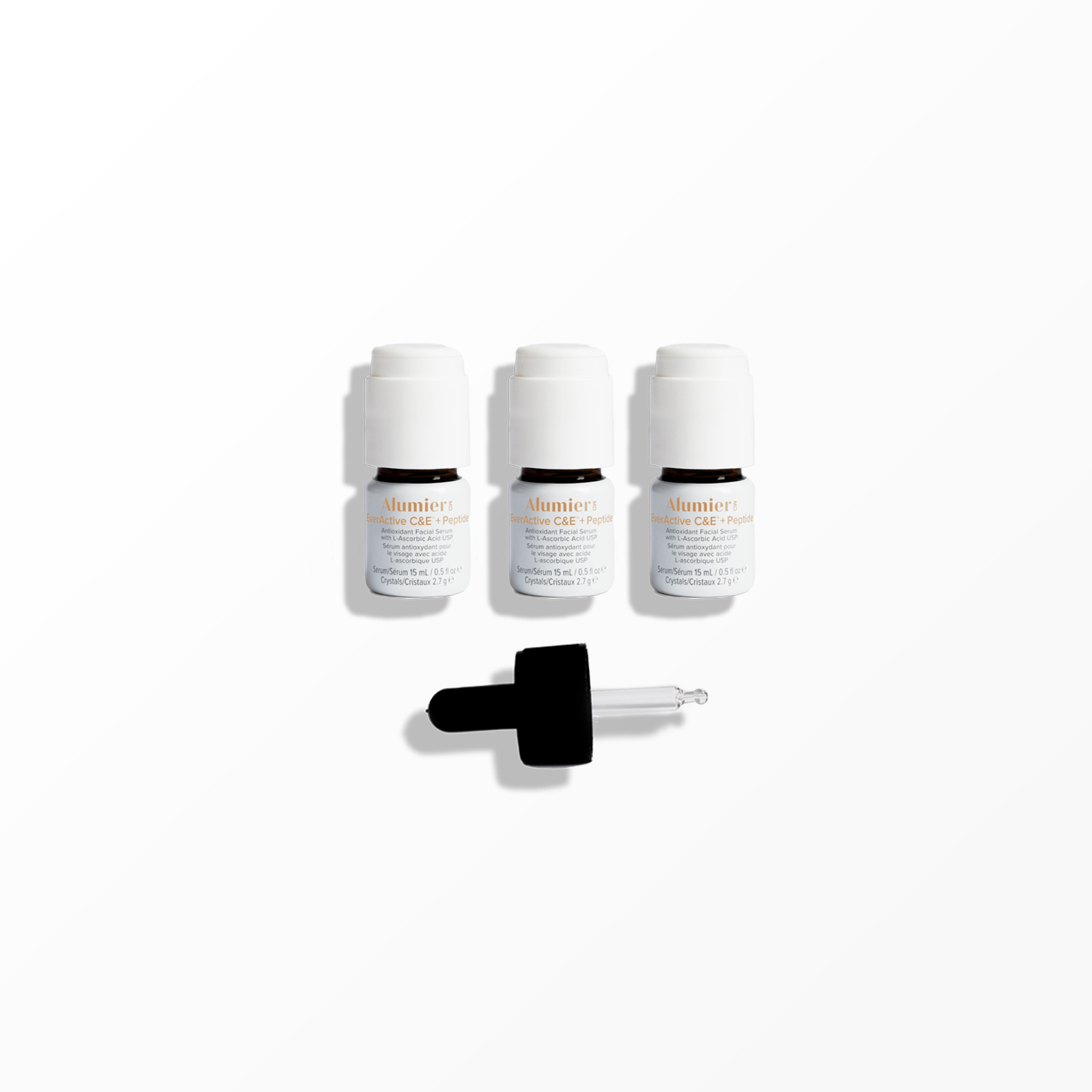 Three small bottles of skincare serum with white caps and a dropper applicator in front of a white background.