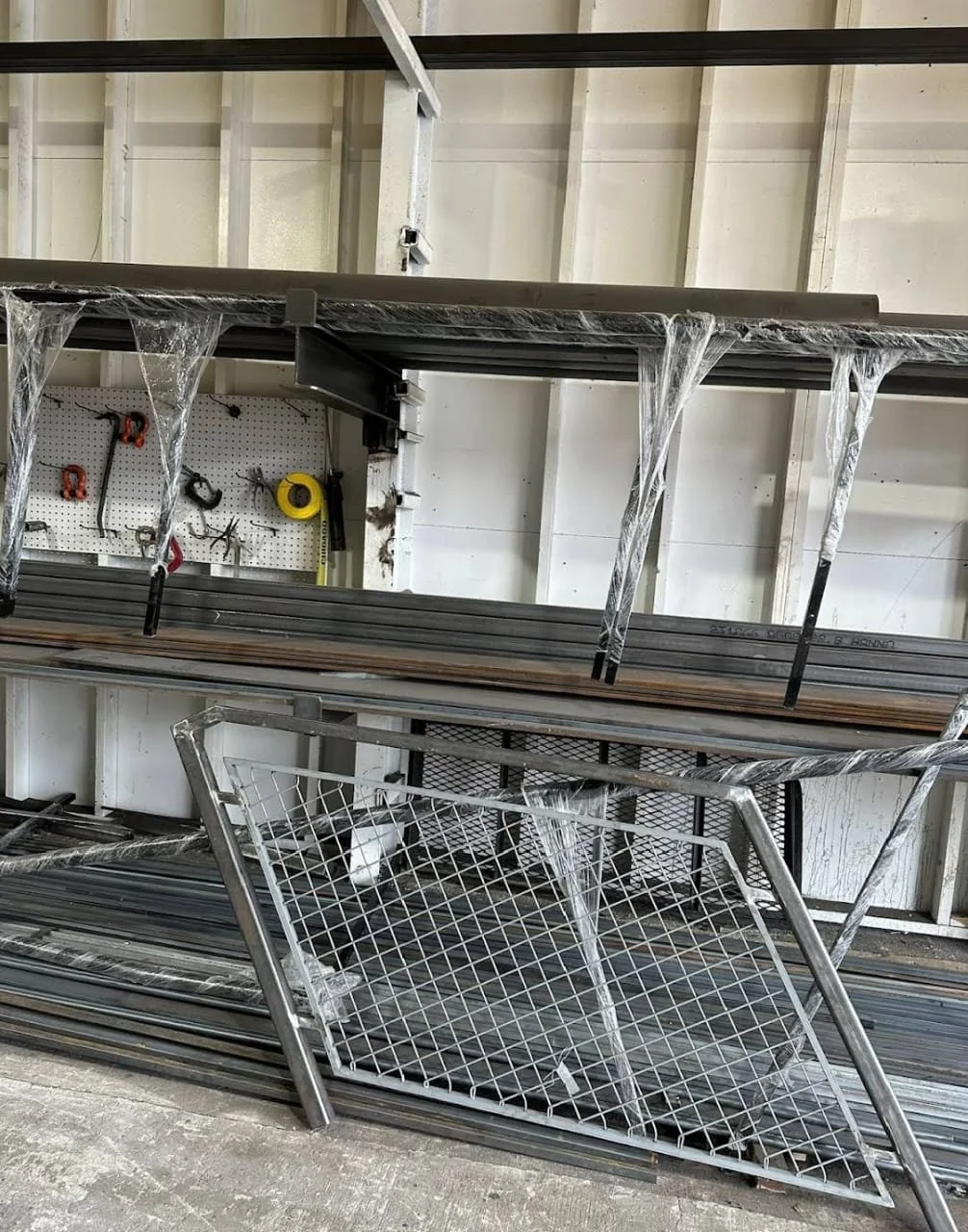 Construction store with metal shelves, tools hanging on a pegboard, and a metal shopping cart tipped over on the concrete floor.
