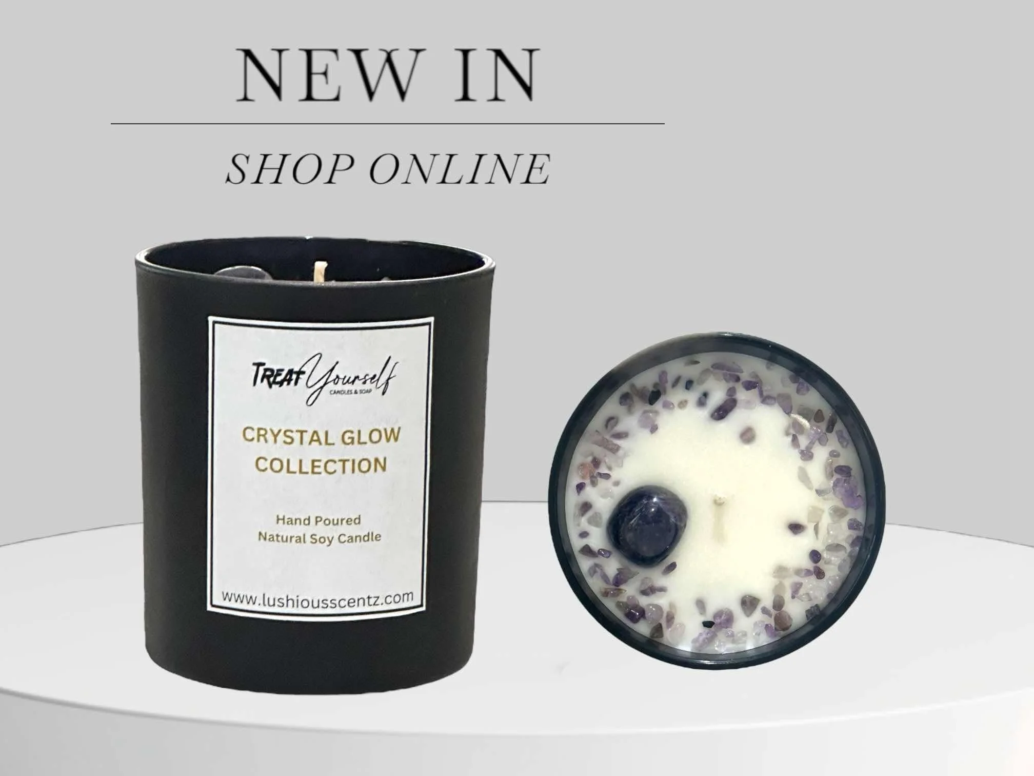 A black scented candle labeled 'Treat Yourself Crystal Glow Collection' with a white label, along with an overhead view of the candle showing white wax and purple and black crystals on top, on a white surface against a light grey background with text 'New In Shop Online'.