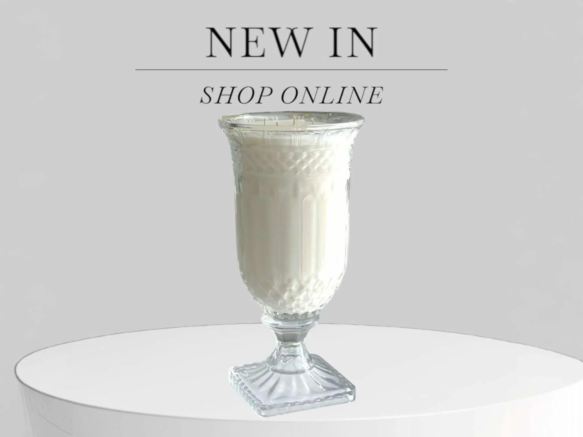 A glass of milk on a white table with a message promoting new online shopping options.
