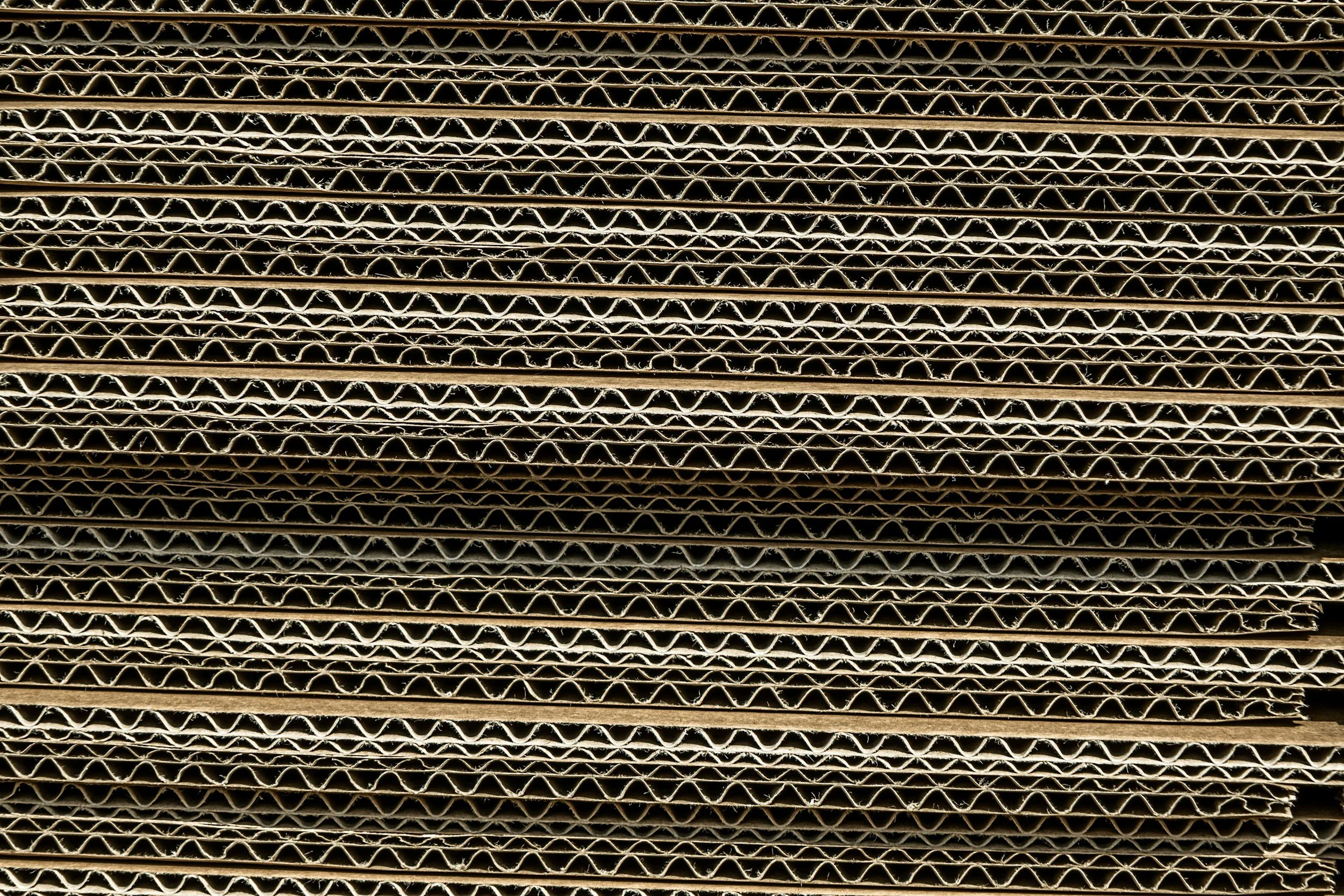 Close-up view of stacked corrugated cardboard sheets.
