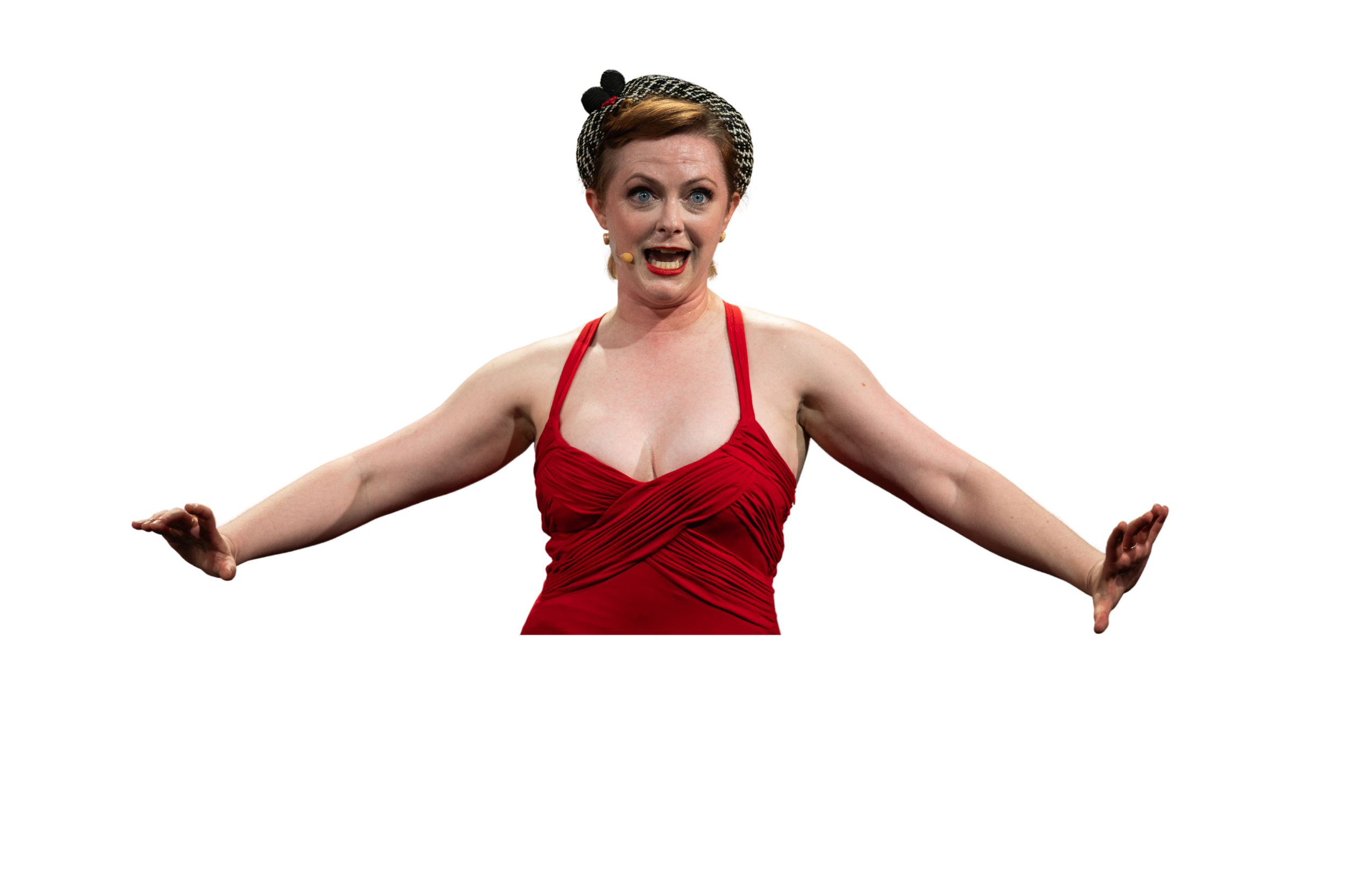 A woman in a red dress with a patterned headband, speaking passionately on stage with arms extended.