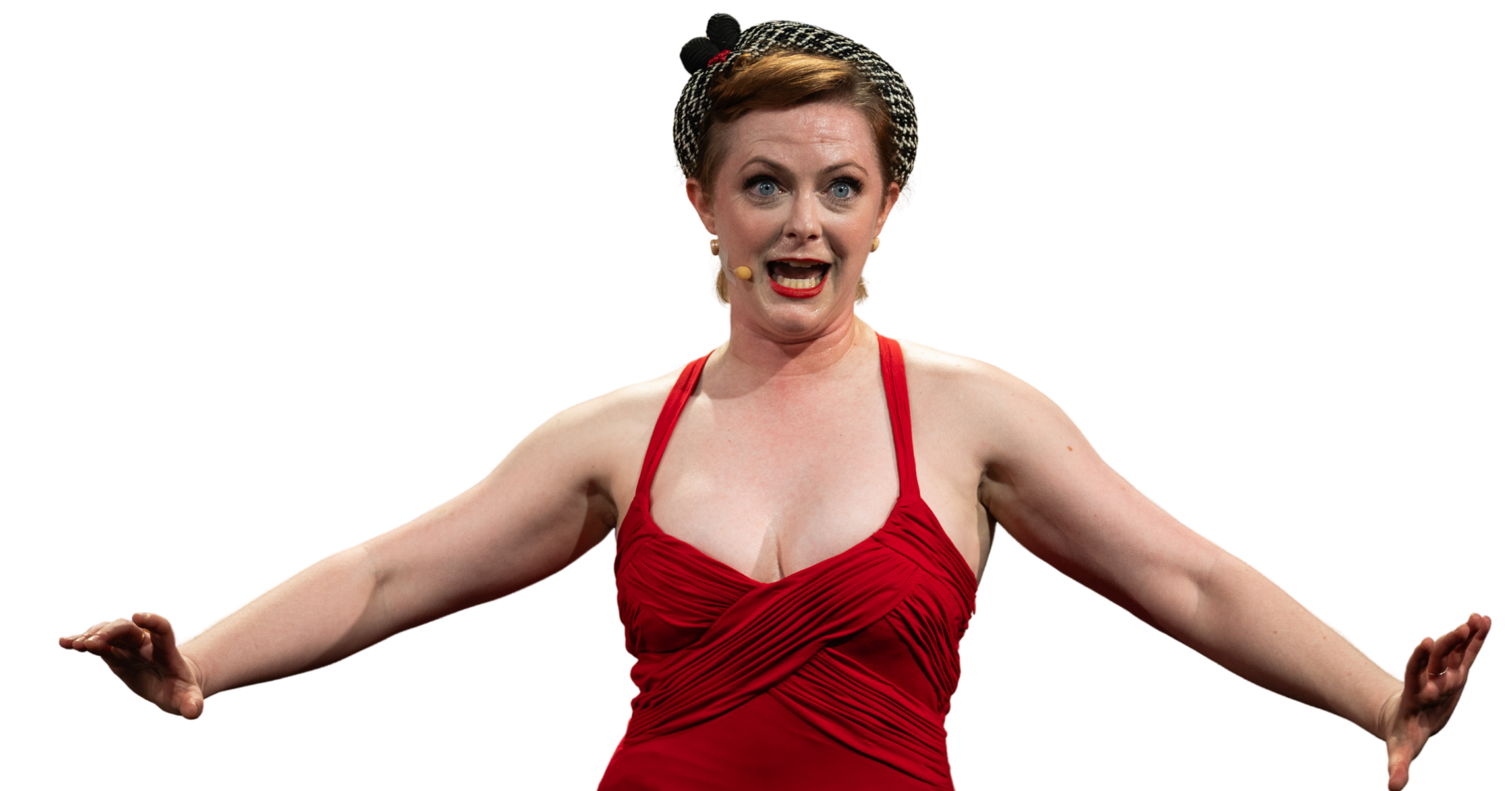 A woman with red hair wearing a red dress and a patterned headscarf is standing with arms outstretched, appearing expressive or surprised.
