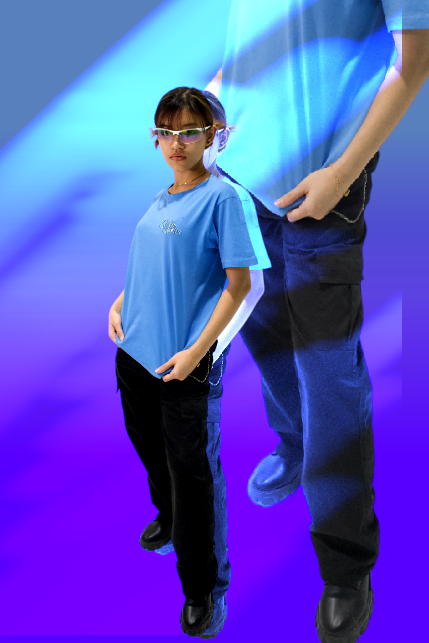 A woman and a girl standing together against a blue and purple digital background, with the woman partly visible, wearing a light blue shirt and black pants, and the girl wearing glasses, a blue T-shirt, and black pants.