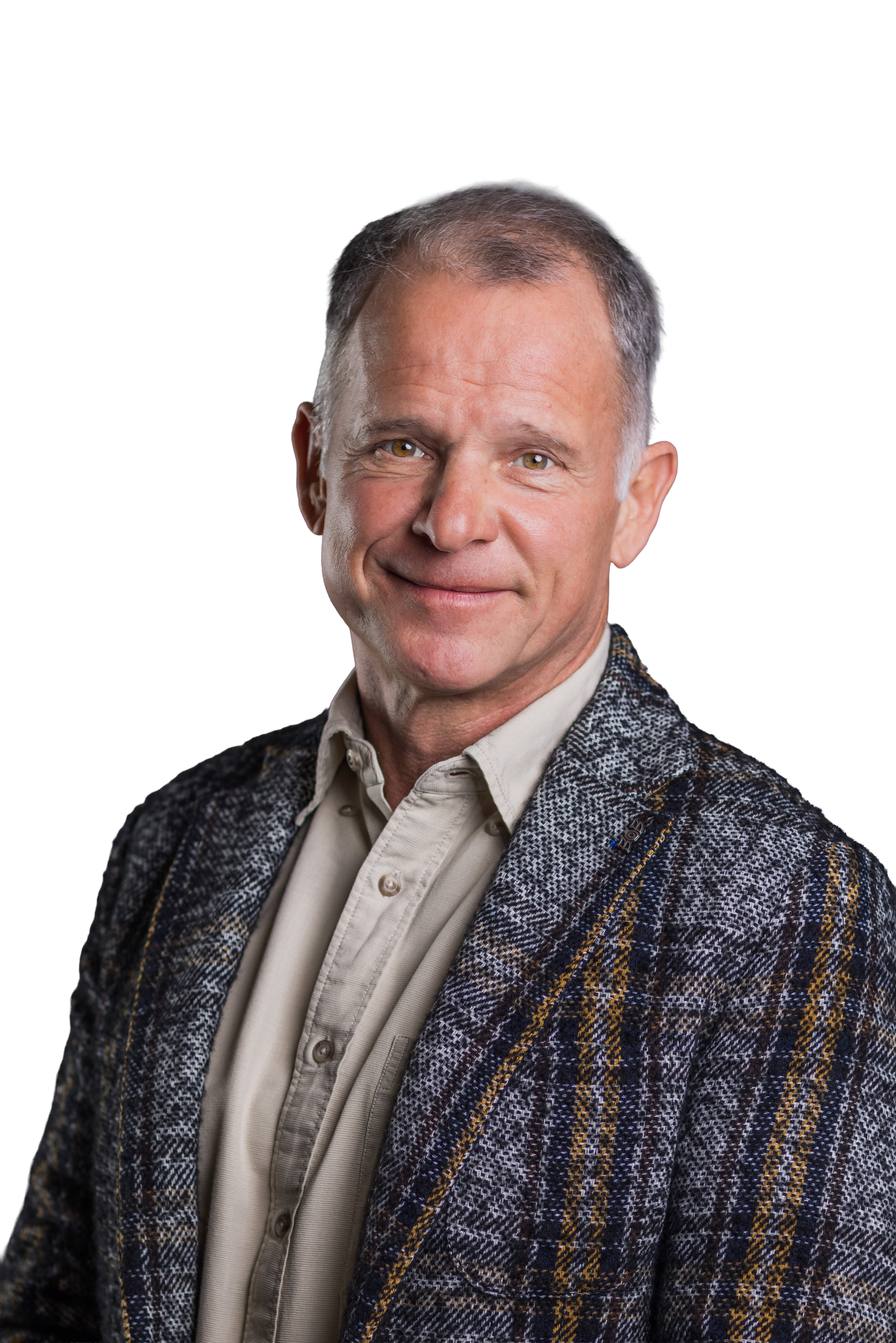 Ein älterer Mann mit grauem Haar, trägt eine beige Hemdjacke und ein kariertes Jackett, lächelt freundlich.