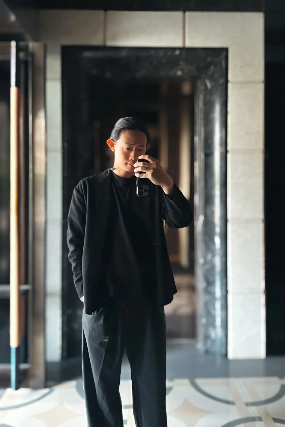 日勿設計：建築師顧問，深色系的服裝與現代風的大理石牆面背景。