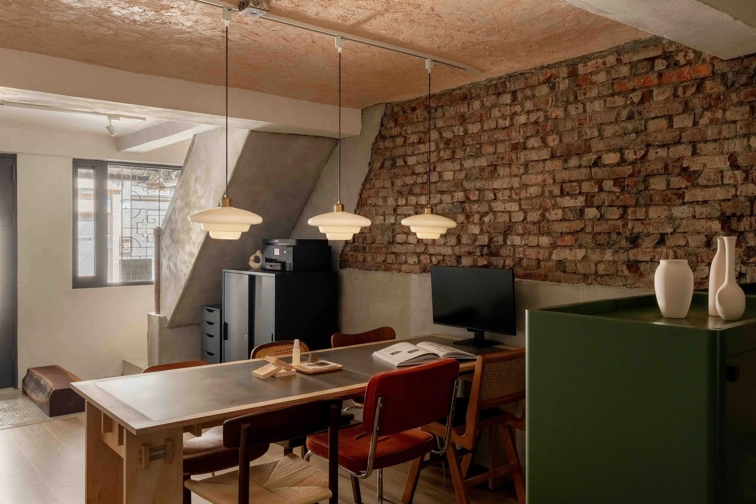 高雄老屋翻新室內設計案例：日勿設計保留 60 年火頭磚牆，以客製化家具、軟裝規劃，打造工業風與復古質感交織的工作室空間。