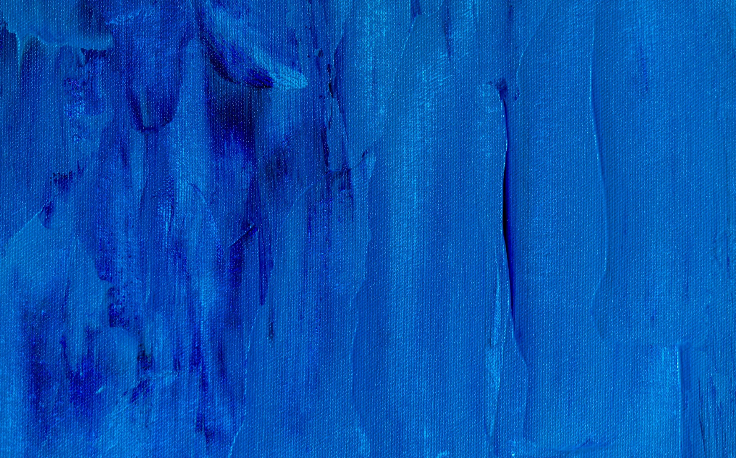Close-up of a textured blue painting with visible brushstrokes.