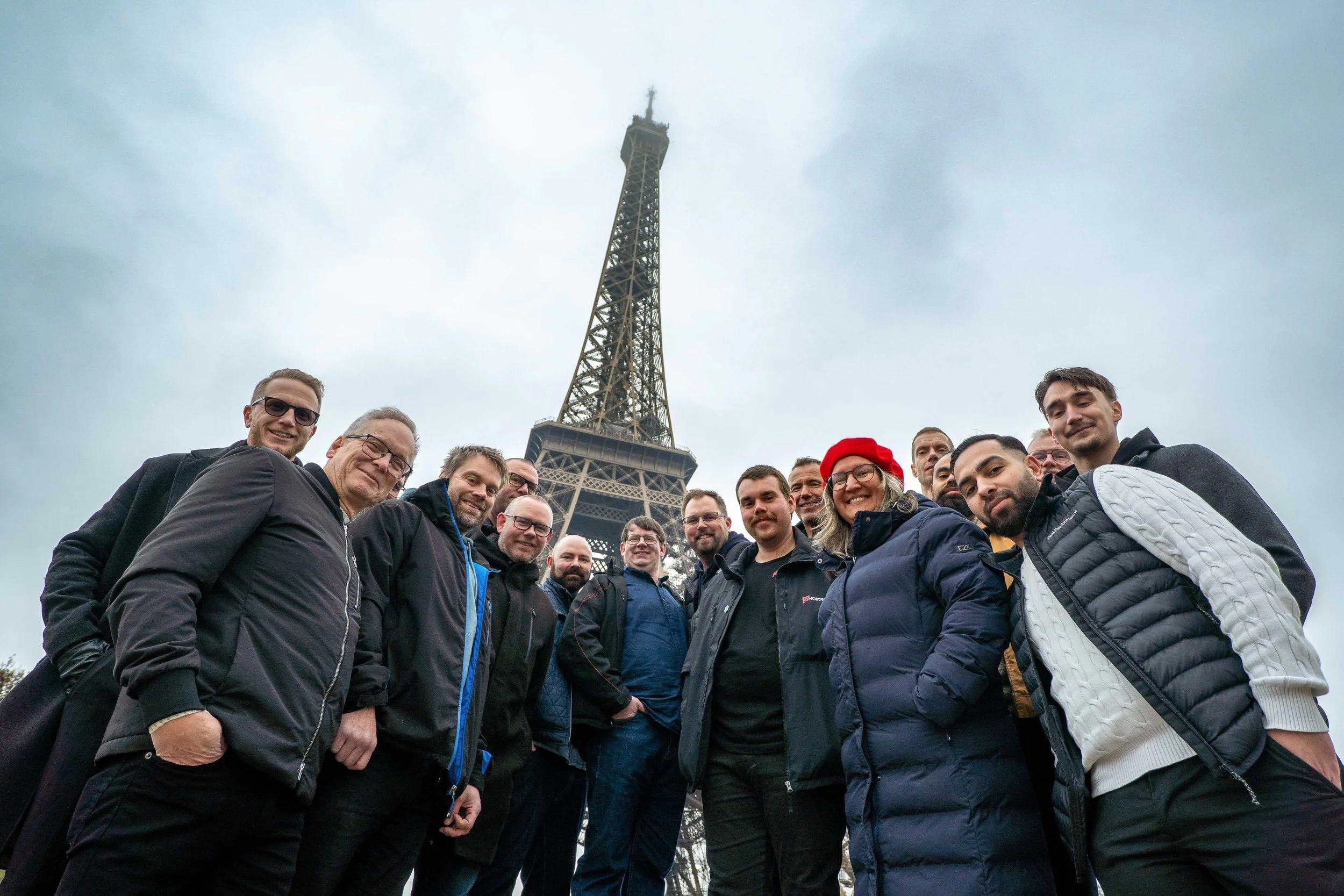 Group of people standing in front of the Eiffel Tower