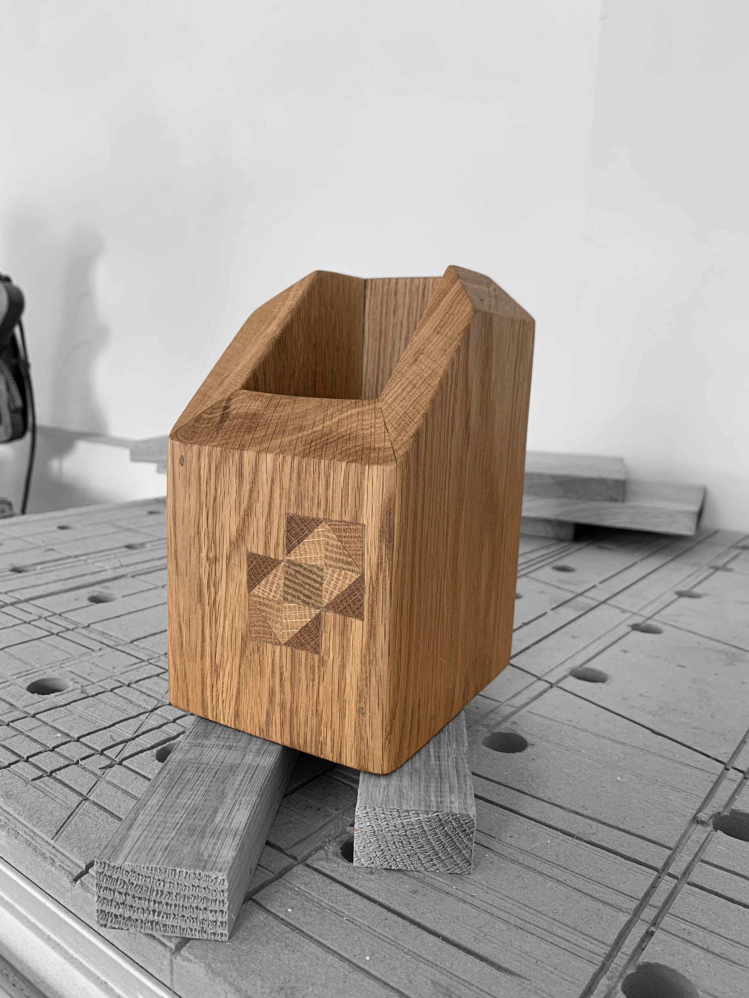 Boîte en bois avec un motif géométrique incrusté.