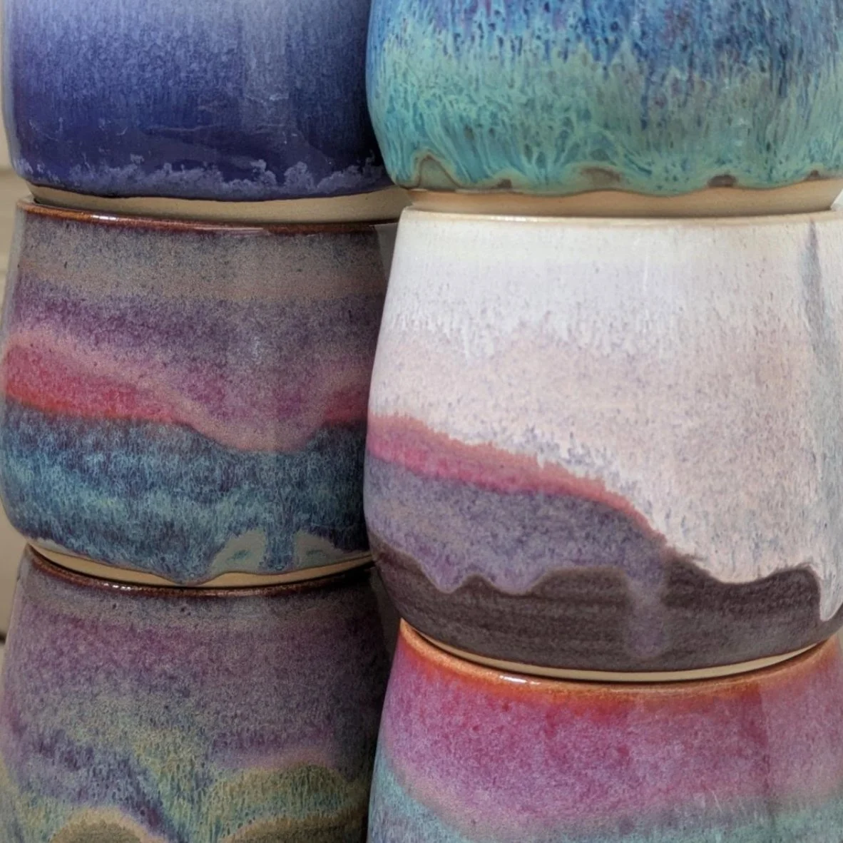 Mehrere bunte Keramikvasen mit gemusterten, pastellfarbenen und abstrakten Designs