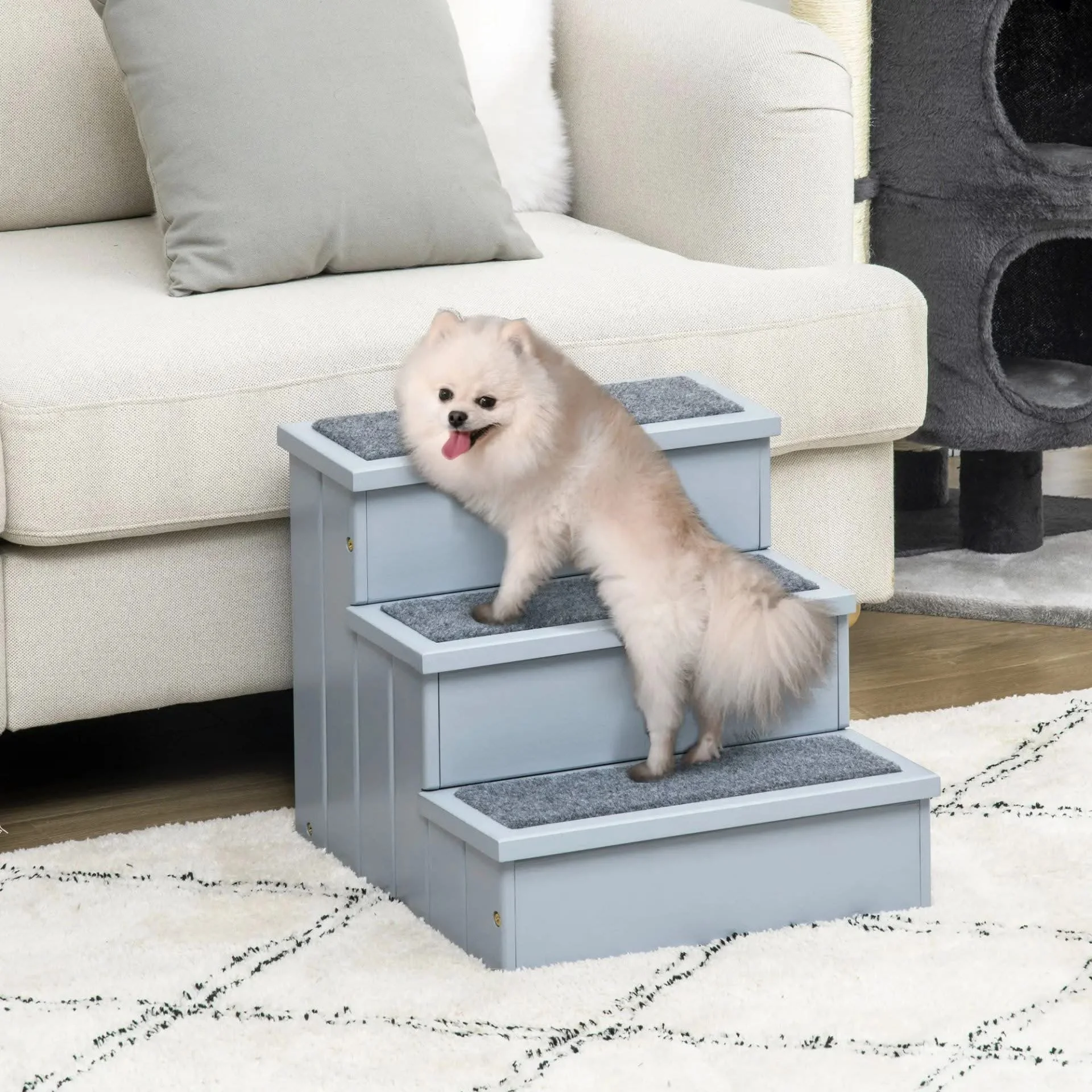 Small fluffy dog climbing stairs in living room with beige sofa and cat tree in background.
