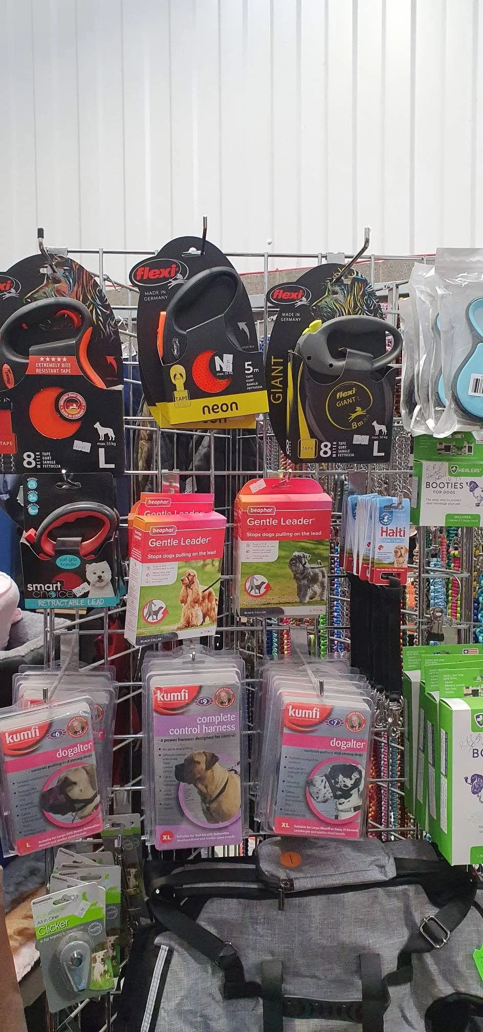 A display of dog accessories including harnesses and leads in a pet store.