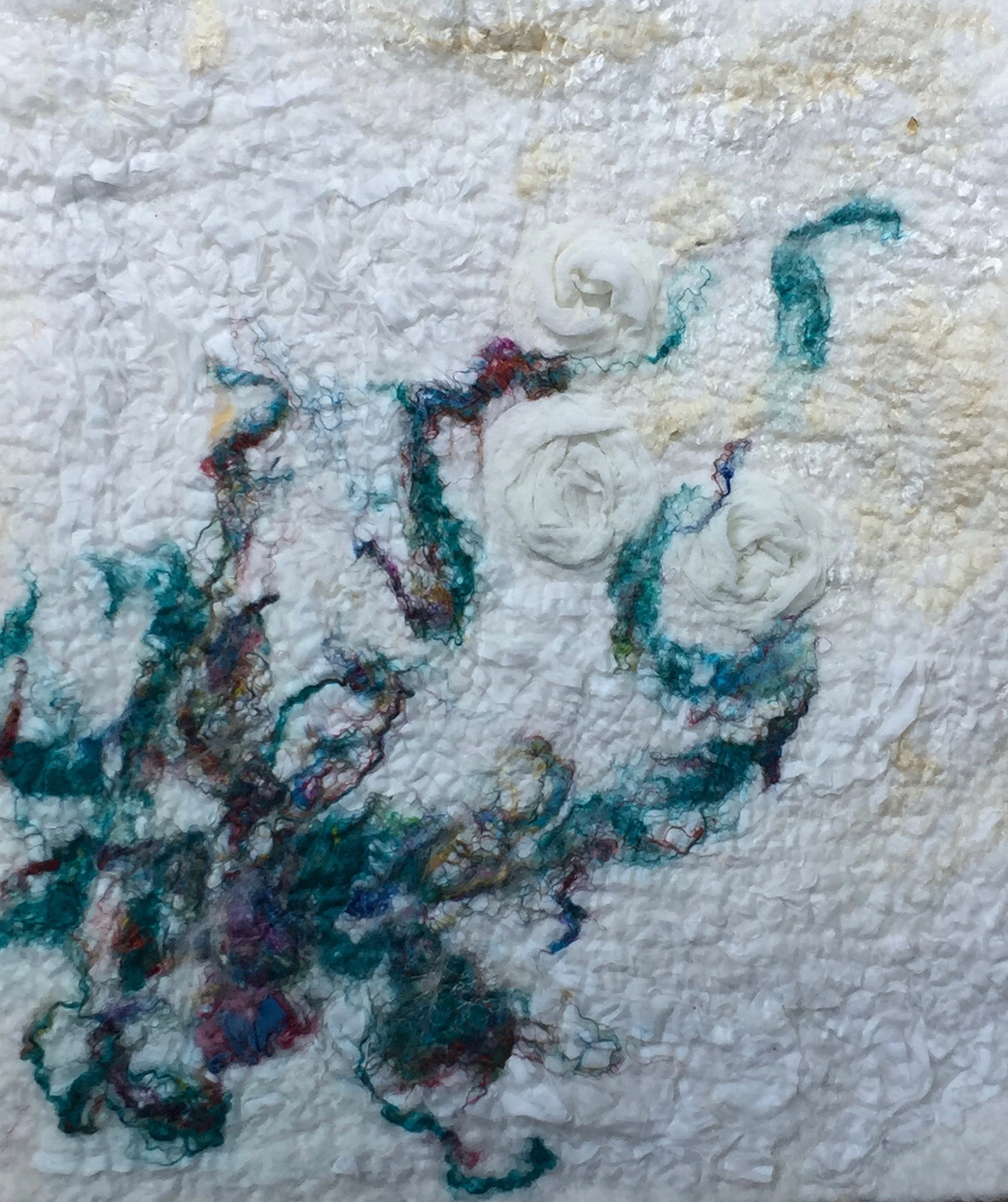 Colored fibre, silk, and thread and white a white roving background.