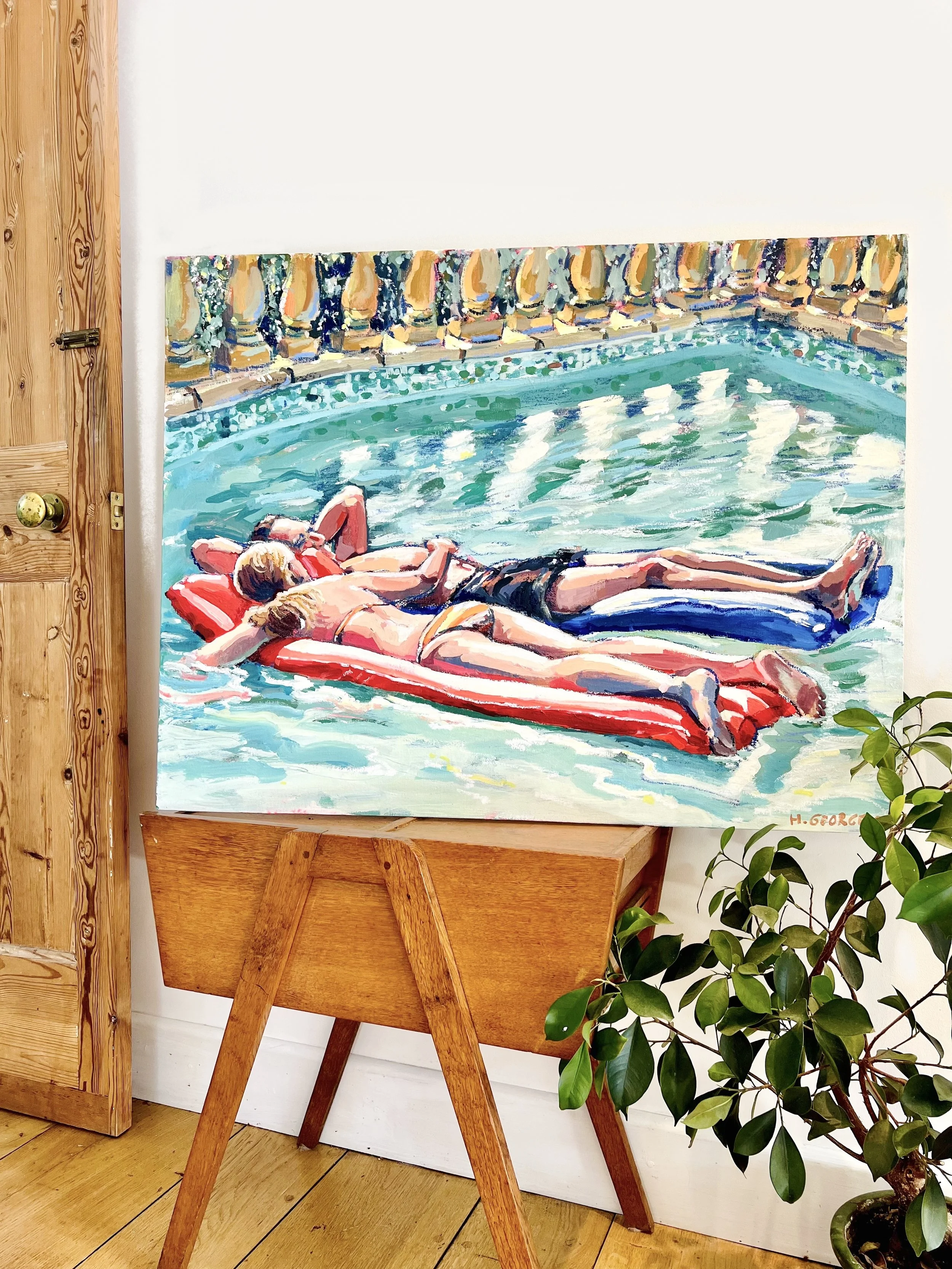 A painting of two people sunbathing on lounge chairs by a swimming pool, signed by H. George.