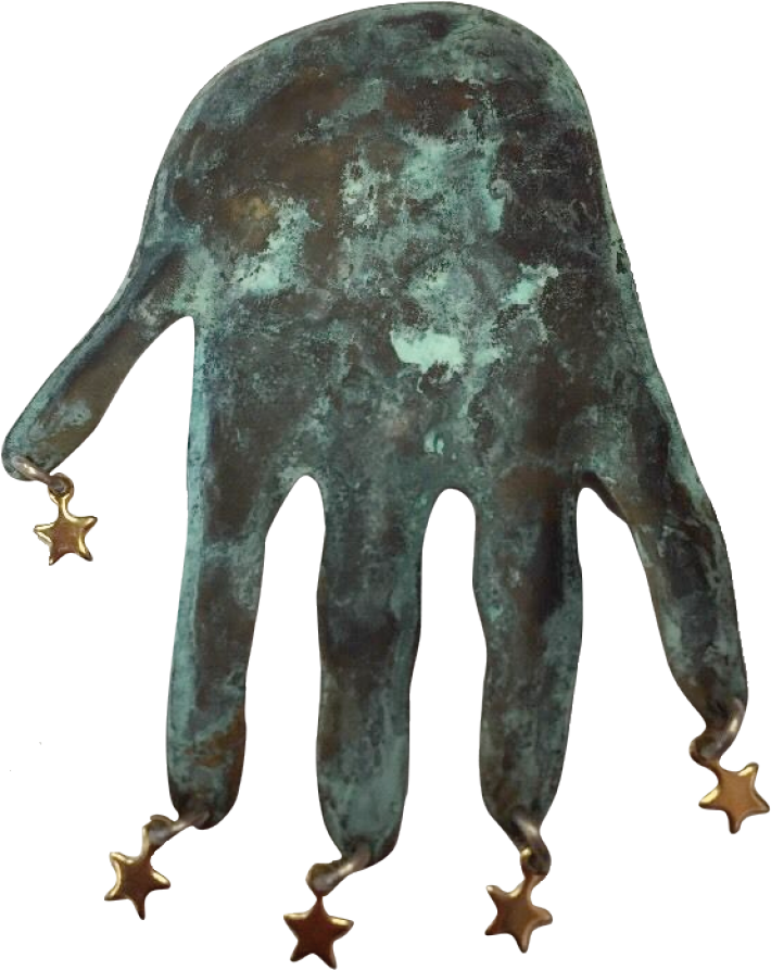 A close-up of a weathered, dark greenish metallic object shaped like an animal with long, pointed extensions resembling fingers or tentacles, decorated with small gold star charms hanging from the tips of each finger.