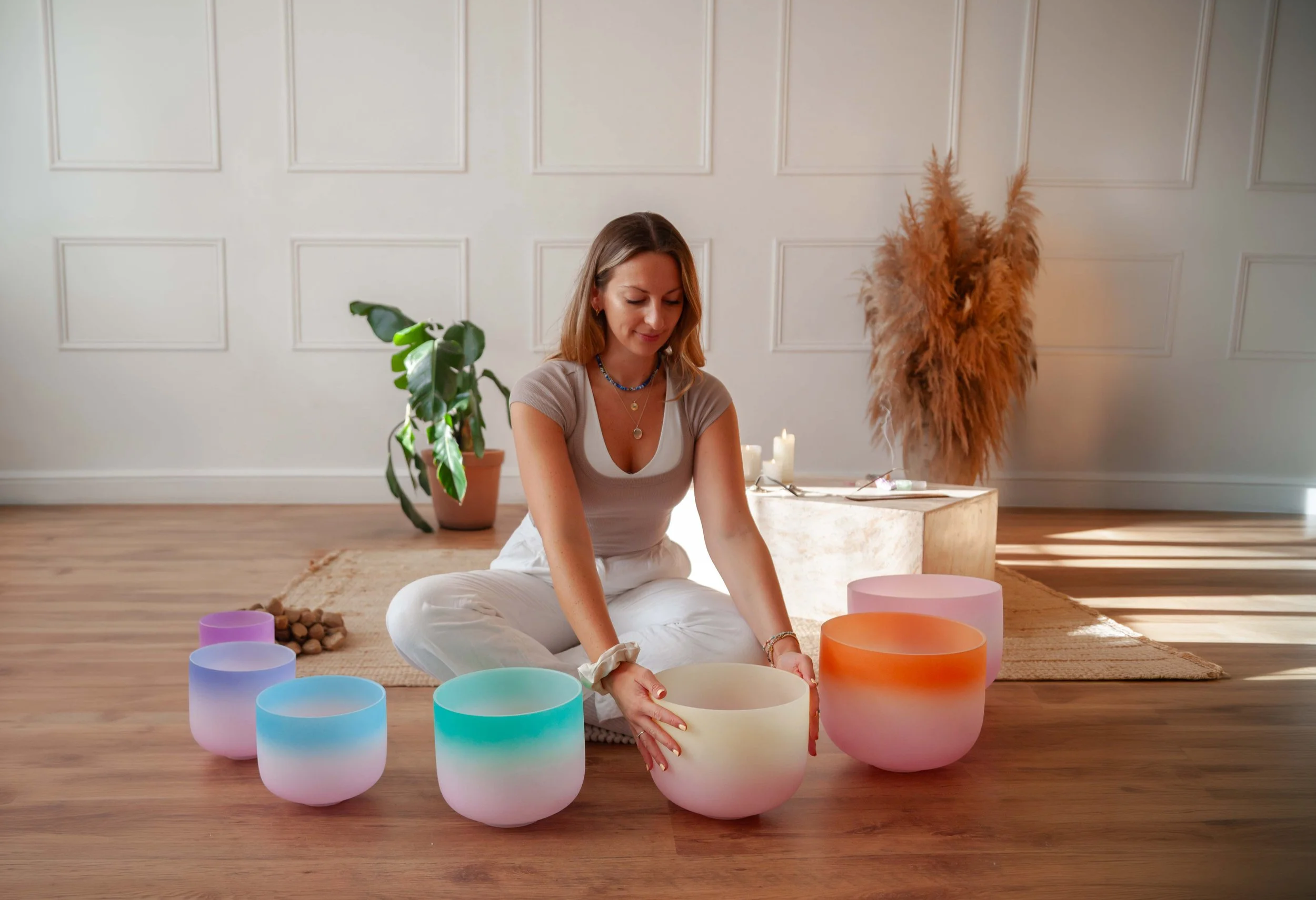sound healing practitioner holding singing bowls