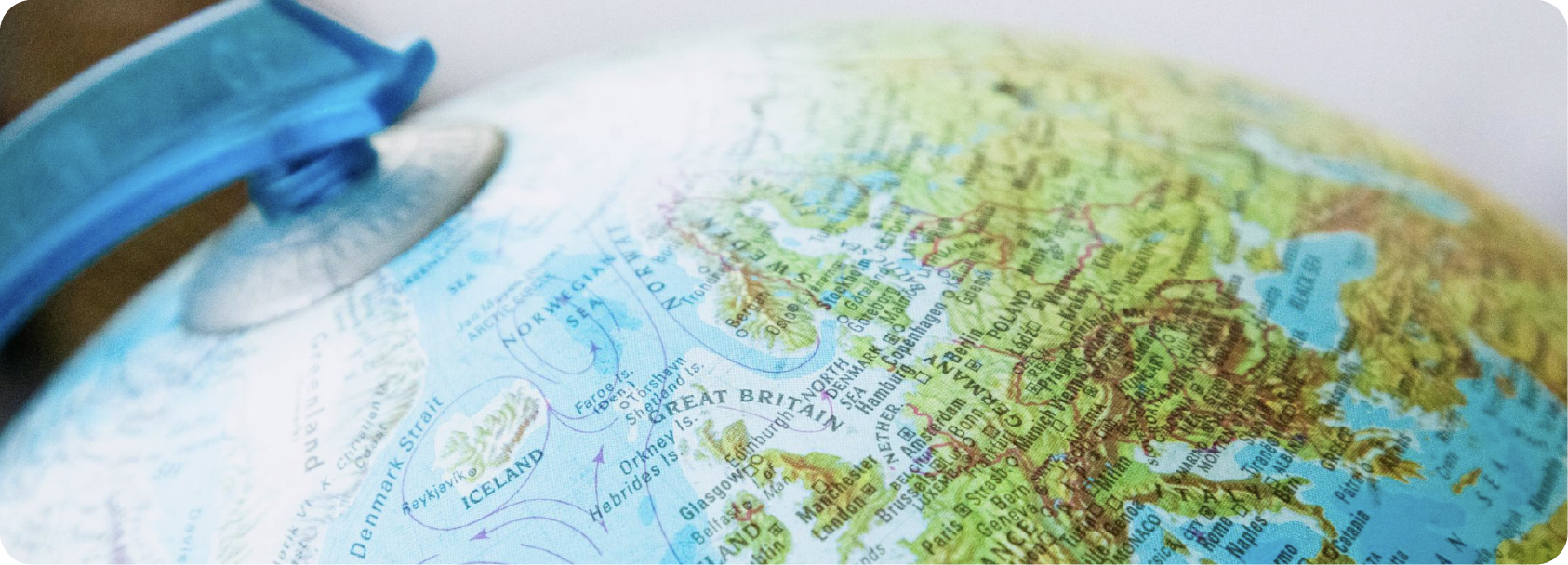 Une boule du monde avec focus sur l'Europe, visible la Grande-Bretagne, la France et l'Islande, avec un support bleu à gauche.