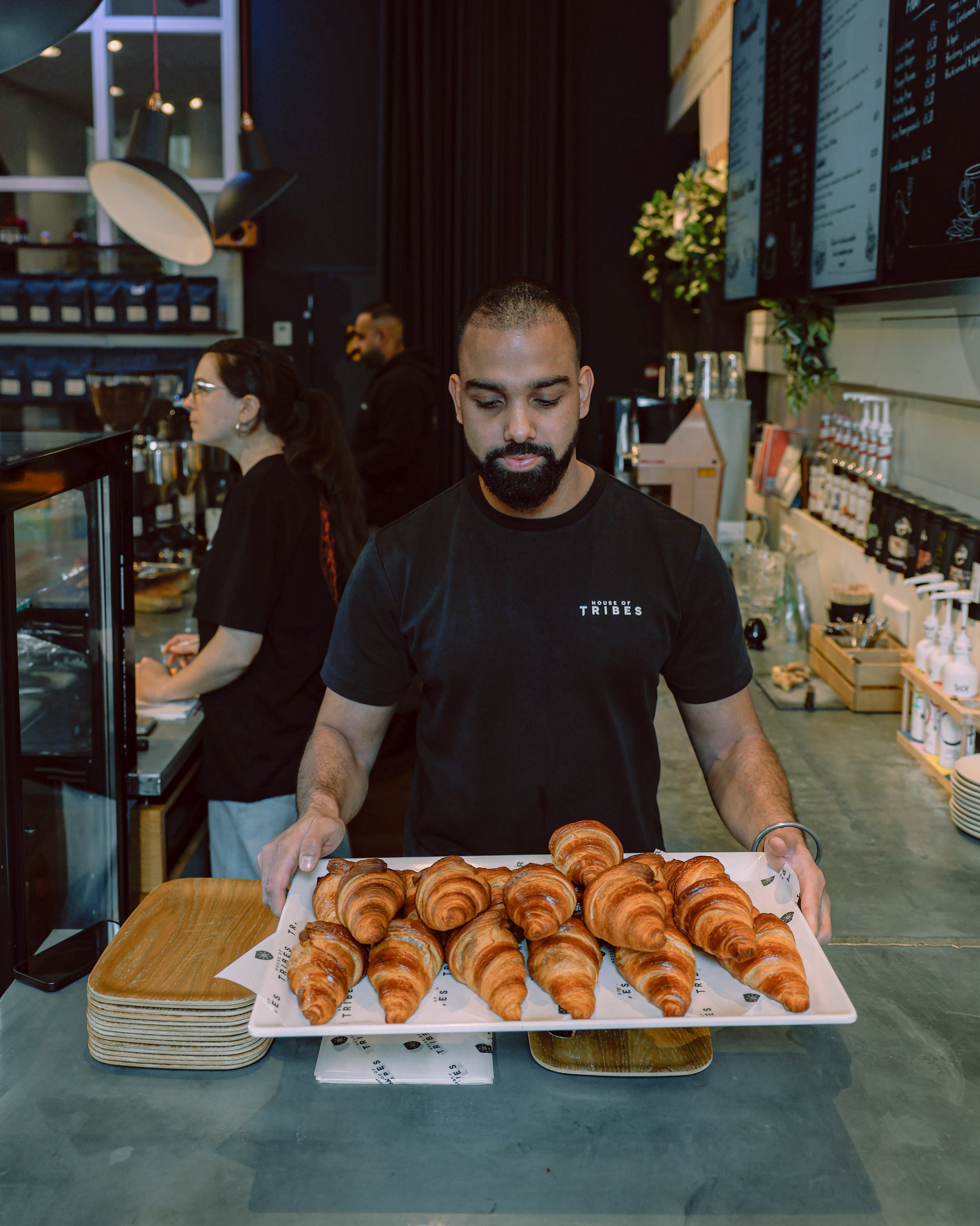 A barista wearing a black t-shirt with 