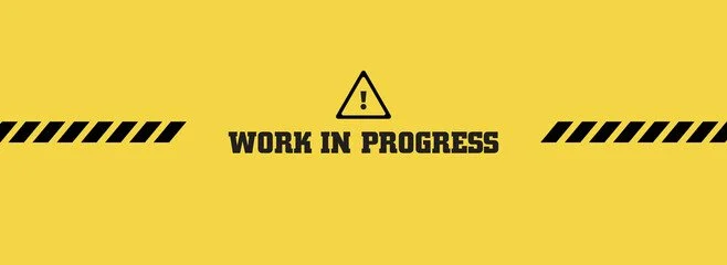 Yellow background with black and yellow striped borders, black text 'WORK IN PROGRESS', and a warning triangle symbol with an exclamation mark.