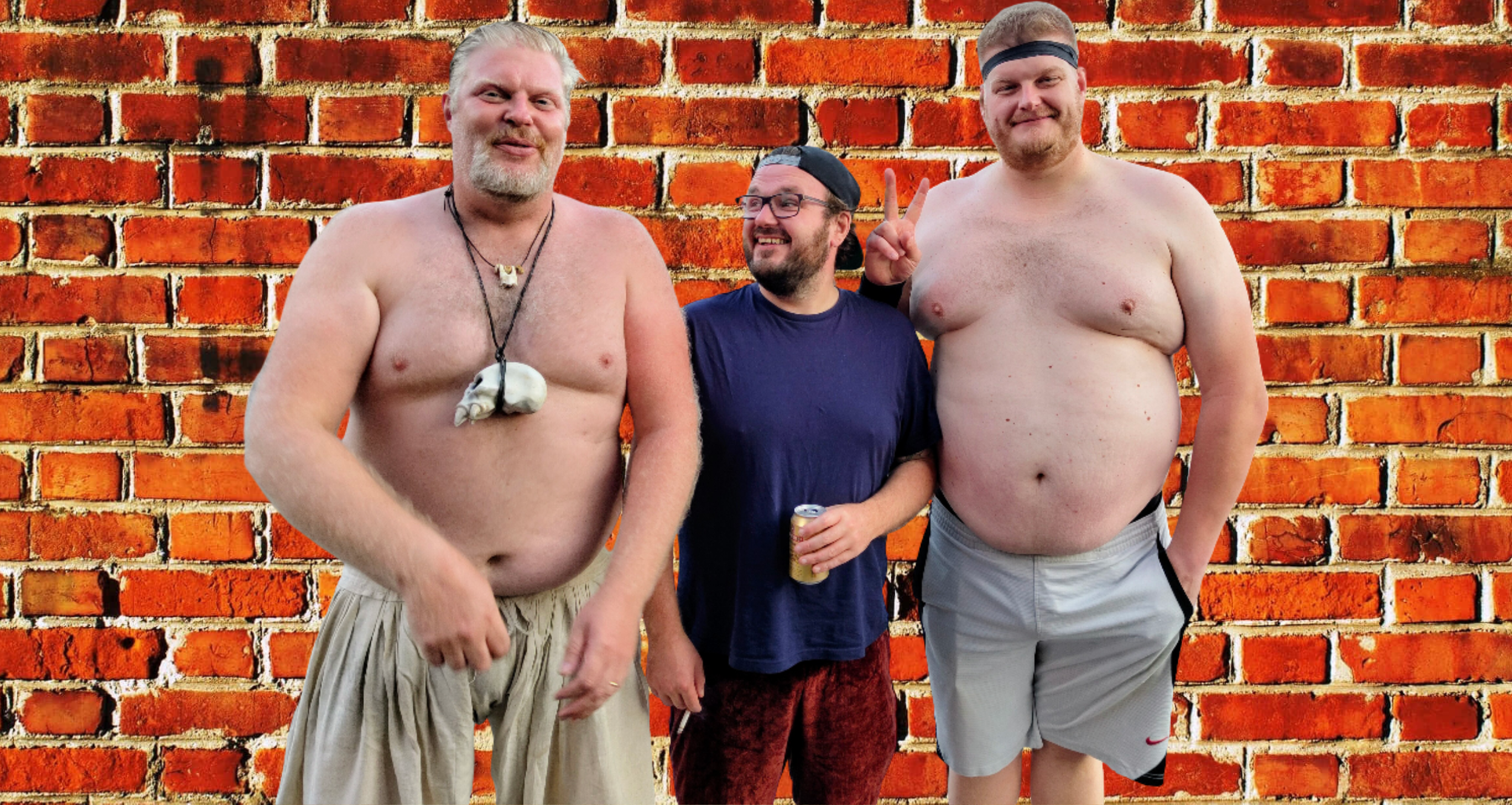 Three men standing shirtless against a brick wall, smiling and making playful gestures.