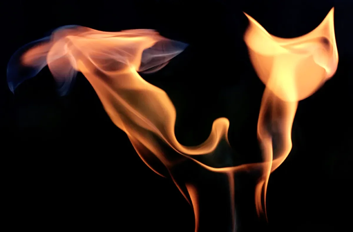 Flames forming the shape of a heart against a black background.
