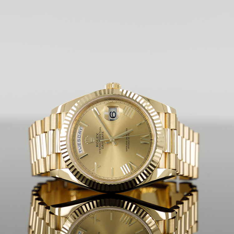 Gold Rolex wristwatch with a fluted bezel, gold dial, date display, and gold bracelet.