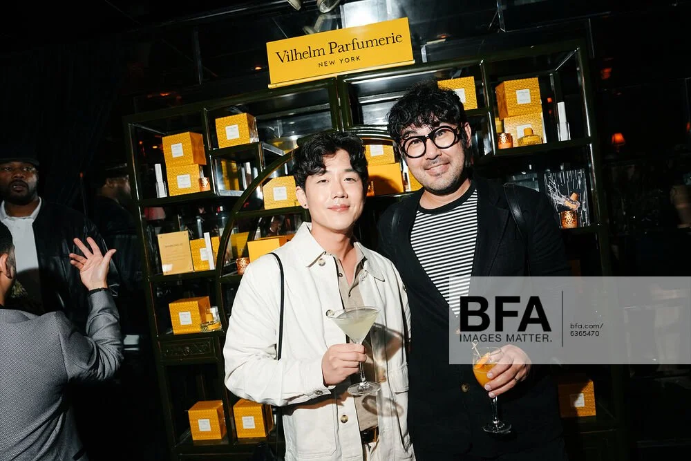 Brute Choi at Vilhelm Parfumerie event in front of a display with yellow perfume boxes.