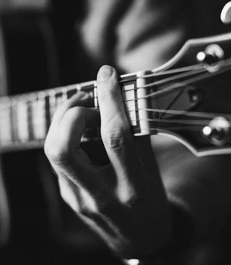 Focus sur les cordes d'une guitare - Photo en noir et blanc