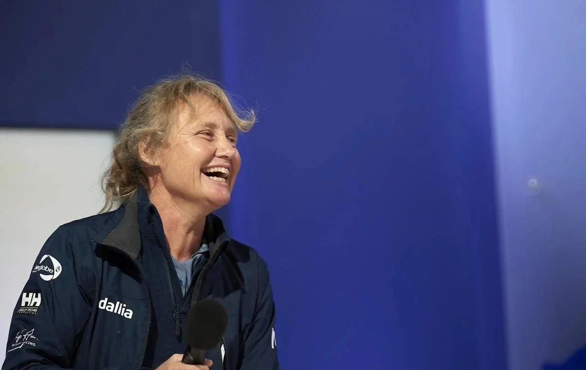 Pip Hare Ocean Racing sailor speaking into a microphone on stage against a blue backdrop.
