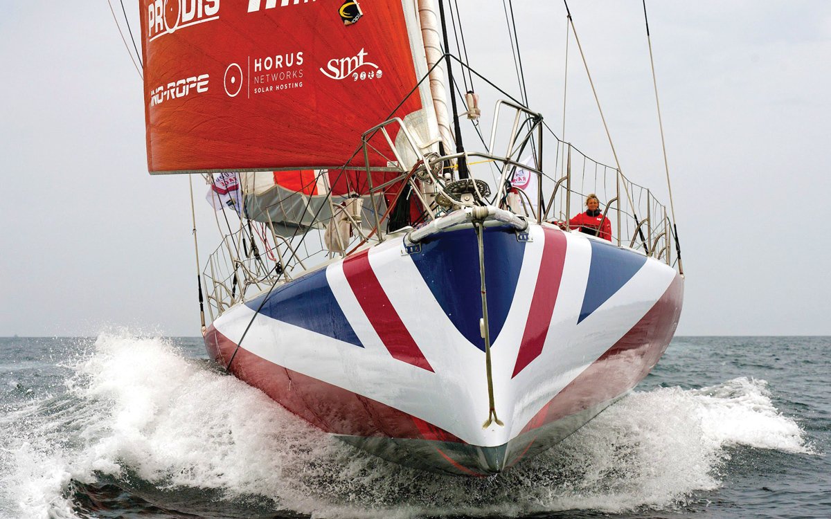 Pip Hare Ocean Racing sailing yacht with a Union Jack design on the bow powering through the ocean.